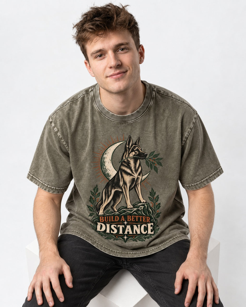 Build A Better Distance Moon Woodcut German Shepherd Dog Graphic Washed Tee in Army Green, worn by a seated model
