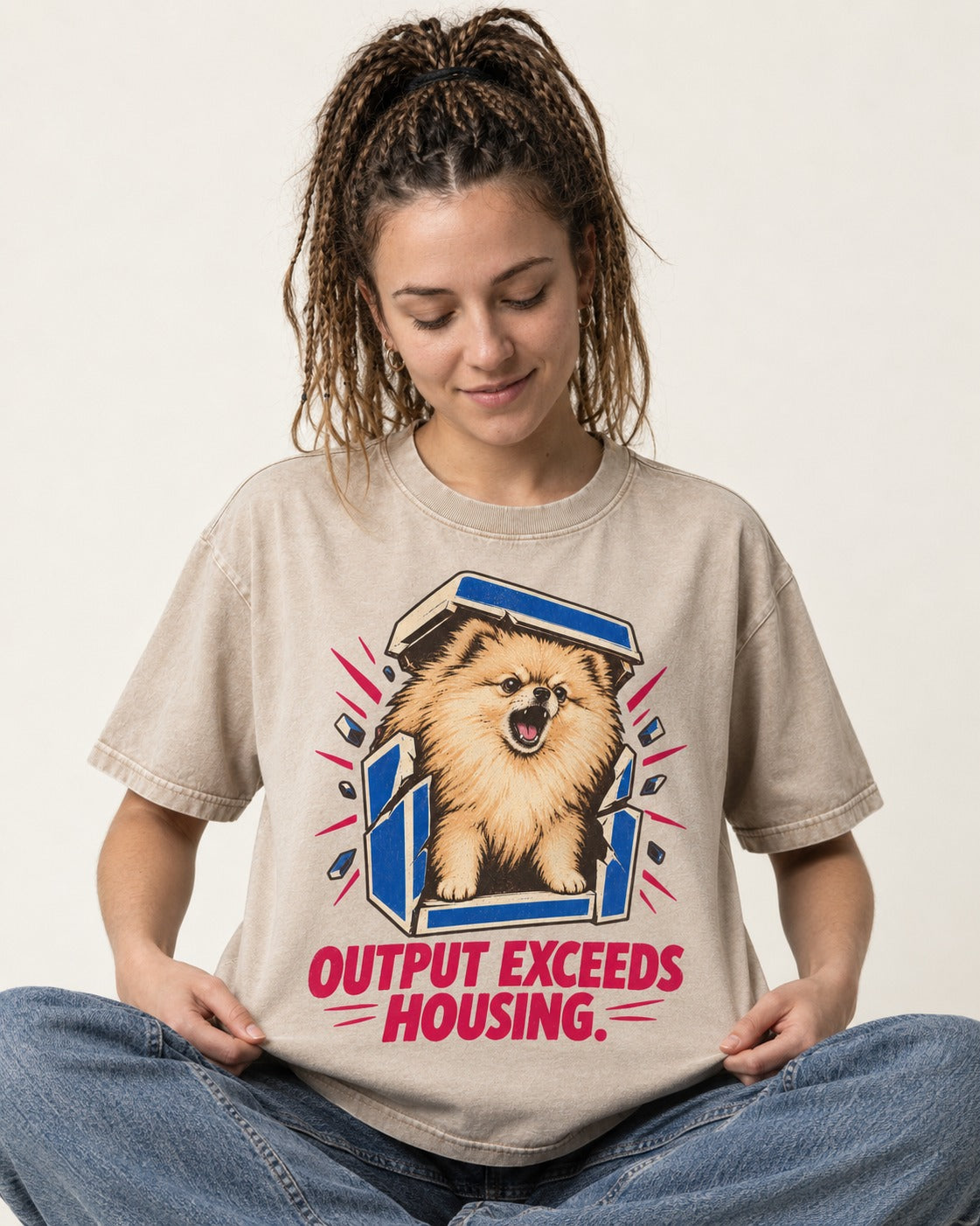 Pomeranian Output Exceeds Housing Bark Compression Graphic Washed Tee in Apricot, worn by a seated model
