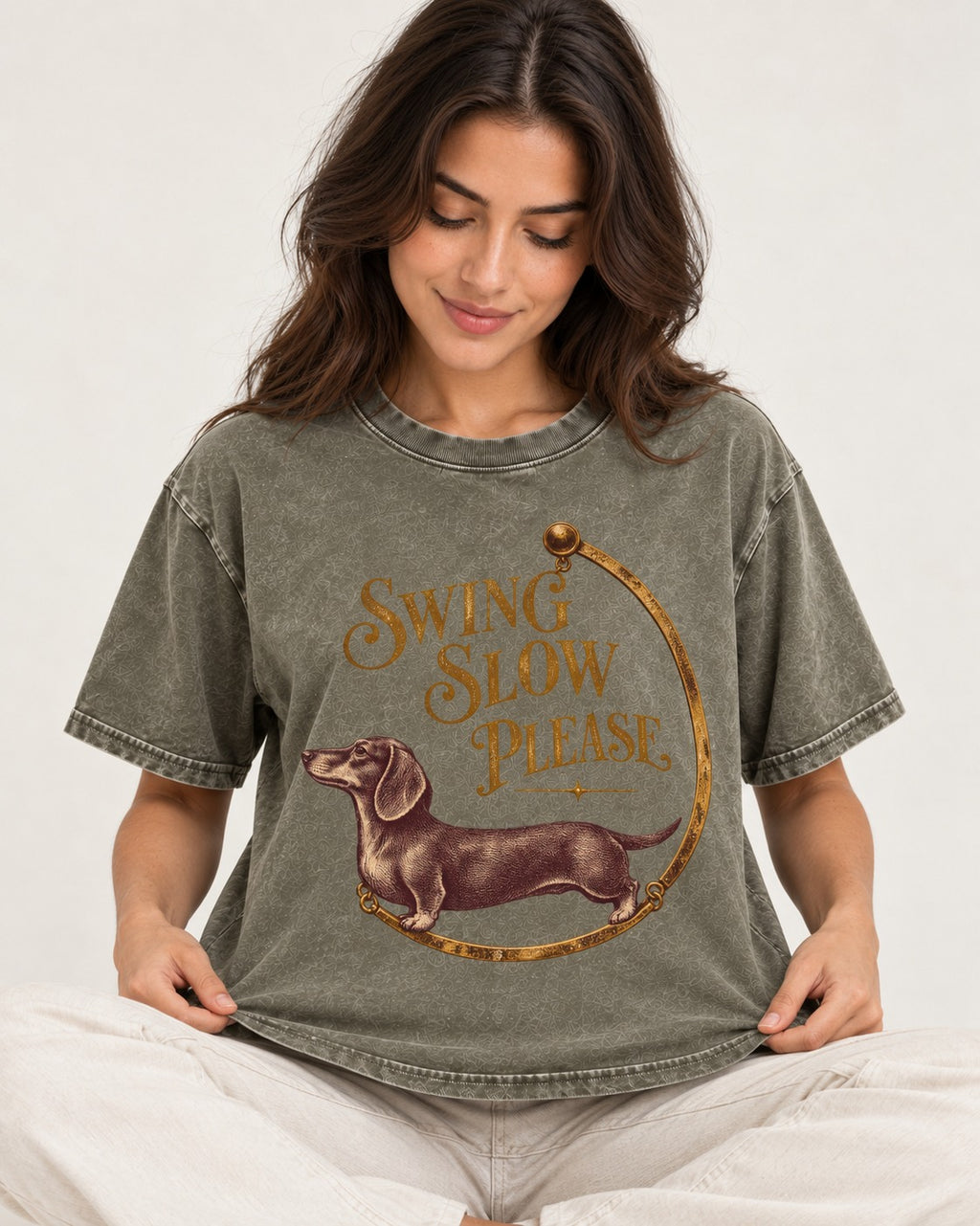 Dachshund Swing Slow Please Necklace Frame Graphic Washed Tee in Army Green, worn by a seated model