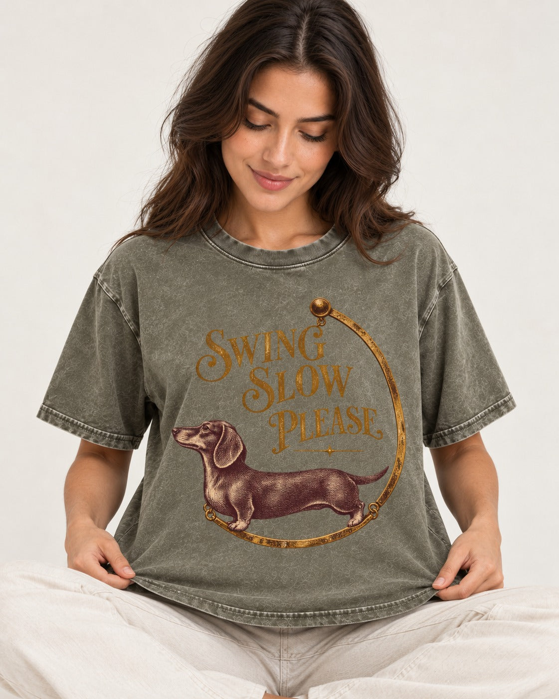 Dachshund Swing Slow Please Necklace Frame Graphic Washed Tee in Army Green, worn by a seated model