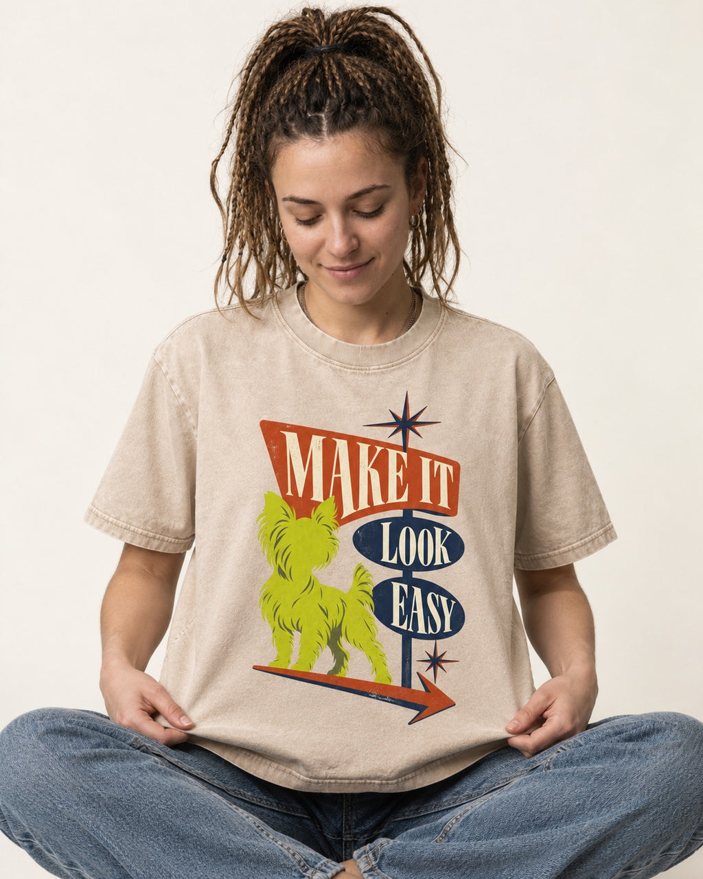 Yorkshire Terrier Make It Look Easy Retro Sign Graphic Washed Tee in Apricot, worn by a seated model