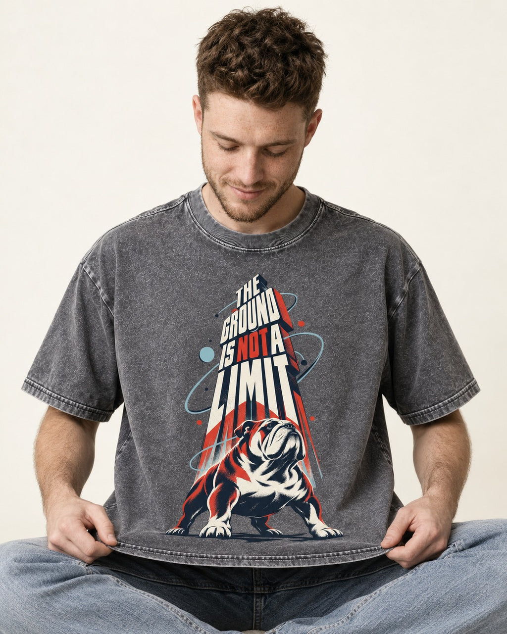 English Bulldog The Ground Is Not a Limit Orbital Graphic Washed Tee in Gray, worn by a seated model