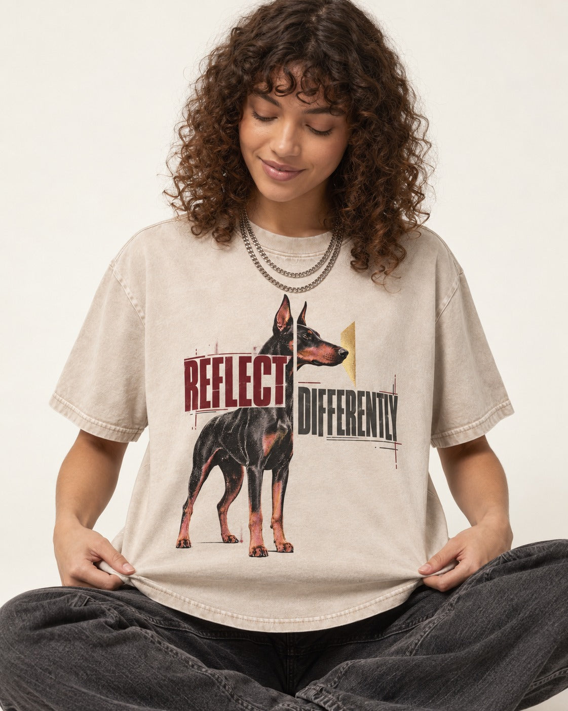 Doberman Reflects Differently Washed Tee in Apricot, worn by a seated model