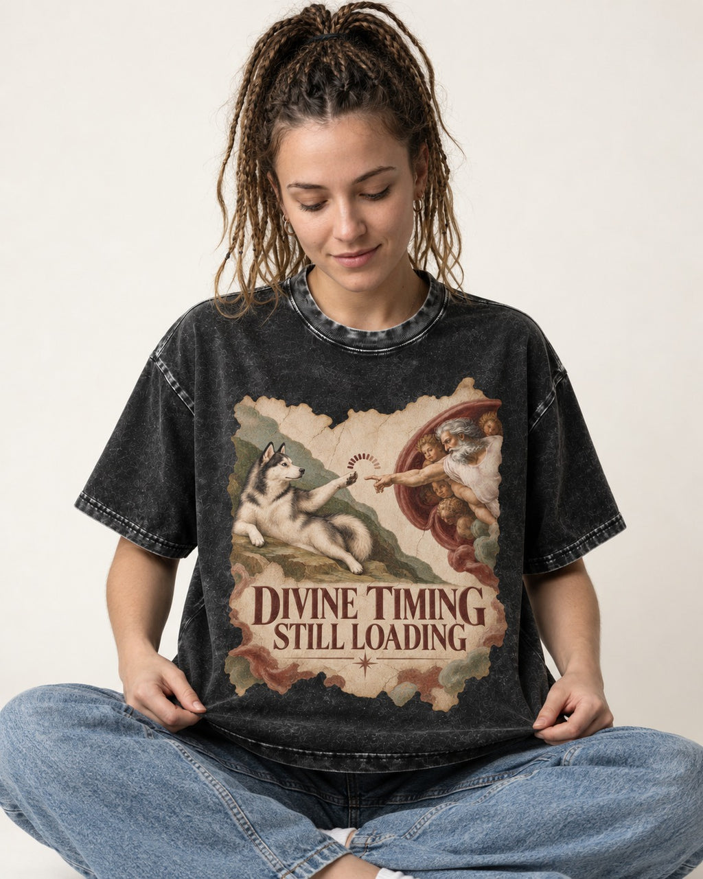 Husky Divine Timing Still Loading Creation Parody Graphic Washed Tee in Black, worn by a seated model