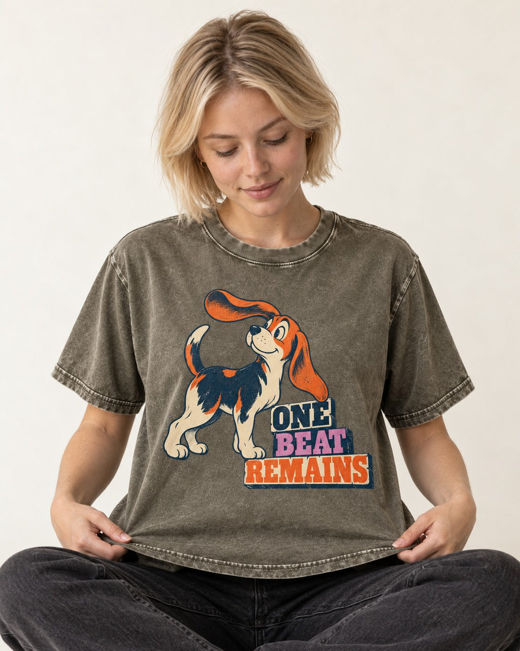Retro Beagle One Beat Remains Washed Tee in Army Green, worn by a seated model