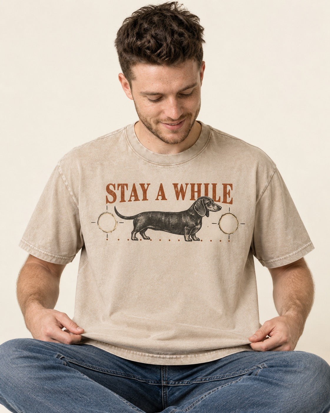 Dachshund Stay A While Ornamental Portrait Graphic Washed Tee in Apricot, worn by a seated model