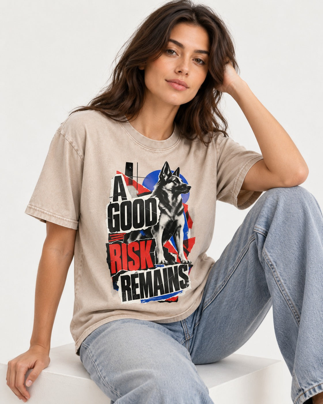 A Good Risk Remains German Shepherd Dog Washed Tee in Apricot, worn by a seated model