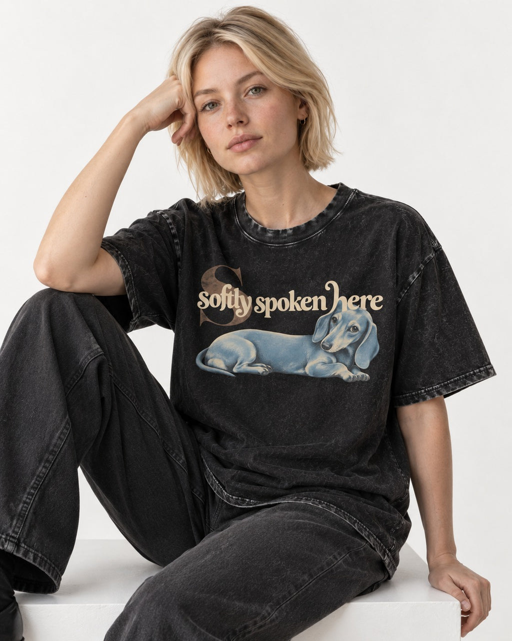 Dachshund Softly Spoken Here Reclining Portrait Graphic Washed Tee in Black, worn by a seated model