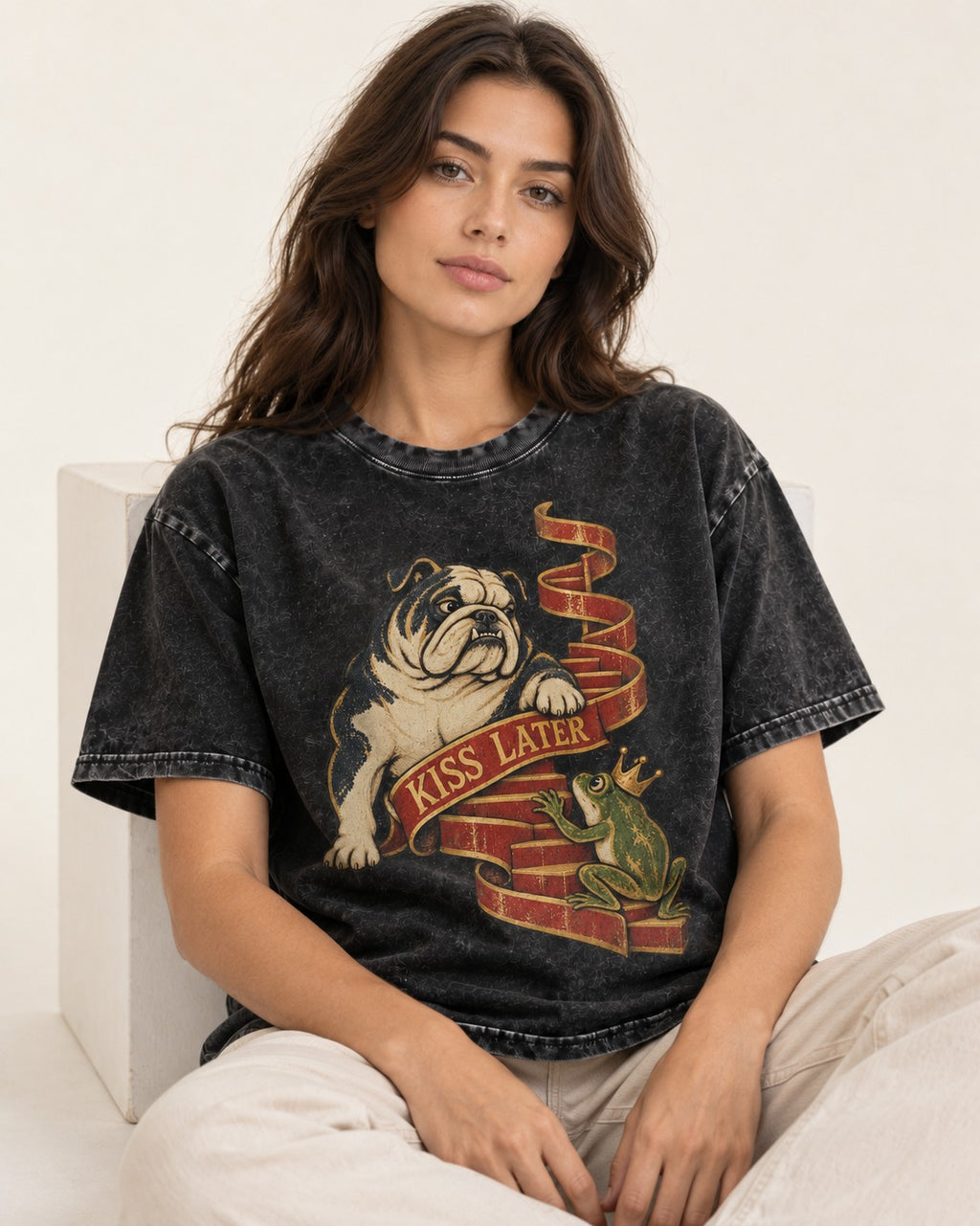 English Bulldog Kiss Later Frog Prince Graphic Washed Tee in Black, worn by a seated model