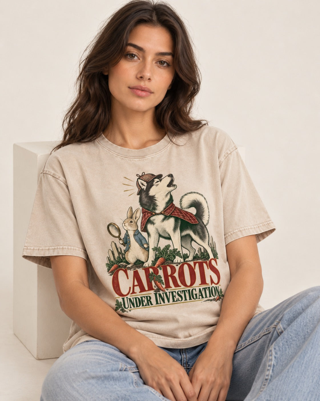 Carrots Under Husky Investigation Washed Tee in Apricot, worn by a seated model