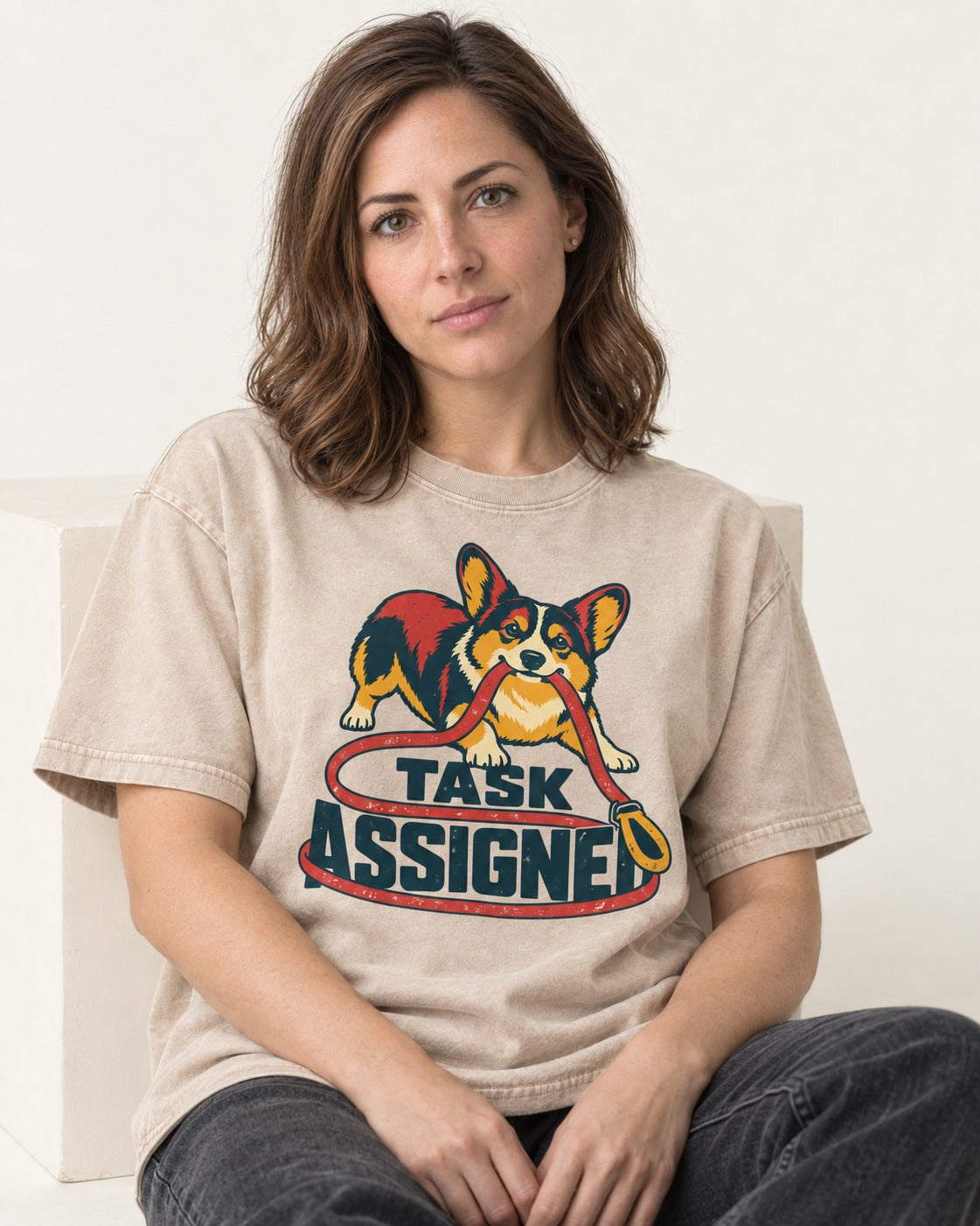 Corgi Task Assigned Washed Tee in Apricot, worn by a seated model