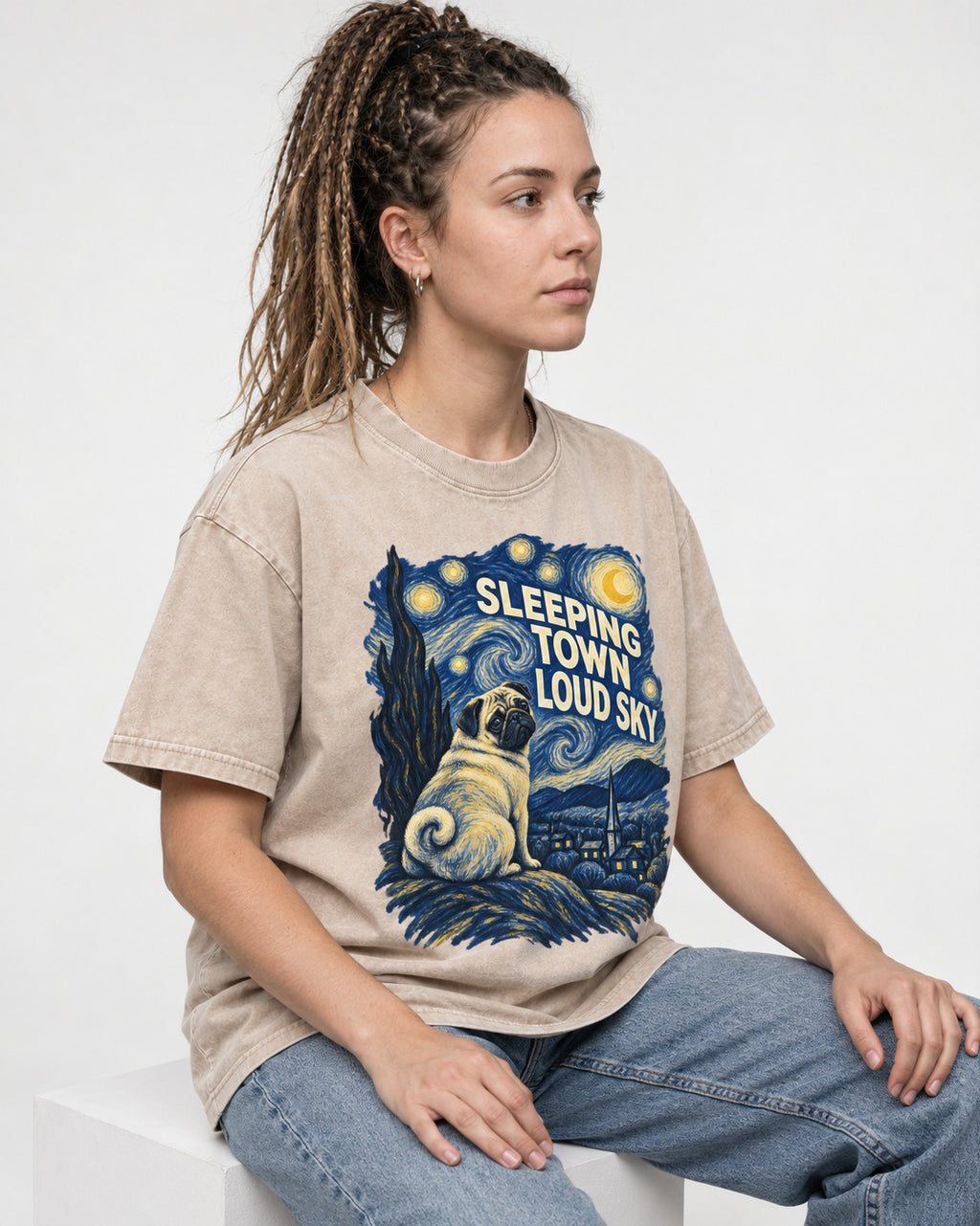 Pug Sleeping Town Loud Sky Starry Night Graphic Washed Tee in Apricot, worn by a seated model