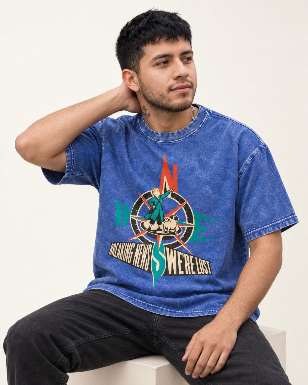 Pug Breaking News We're Lost Compass Graphic Washed Tee in Royal Blue, worn by a seated model