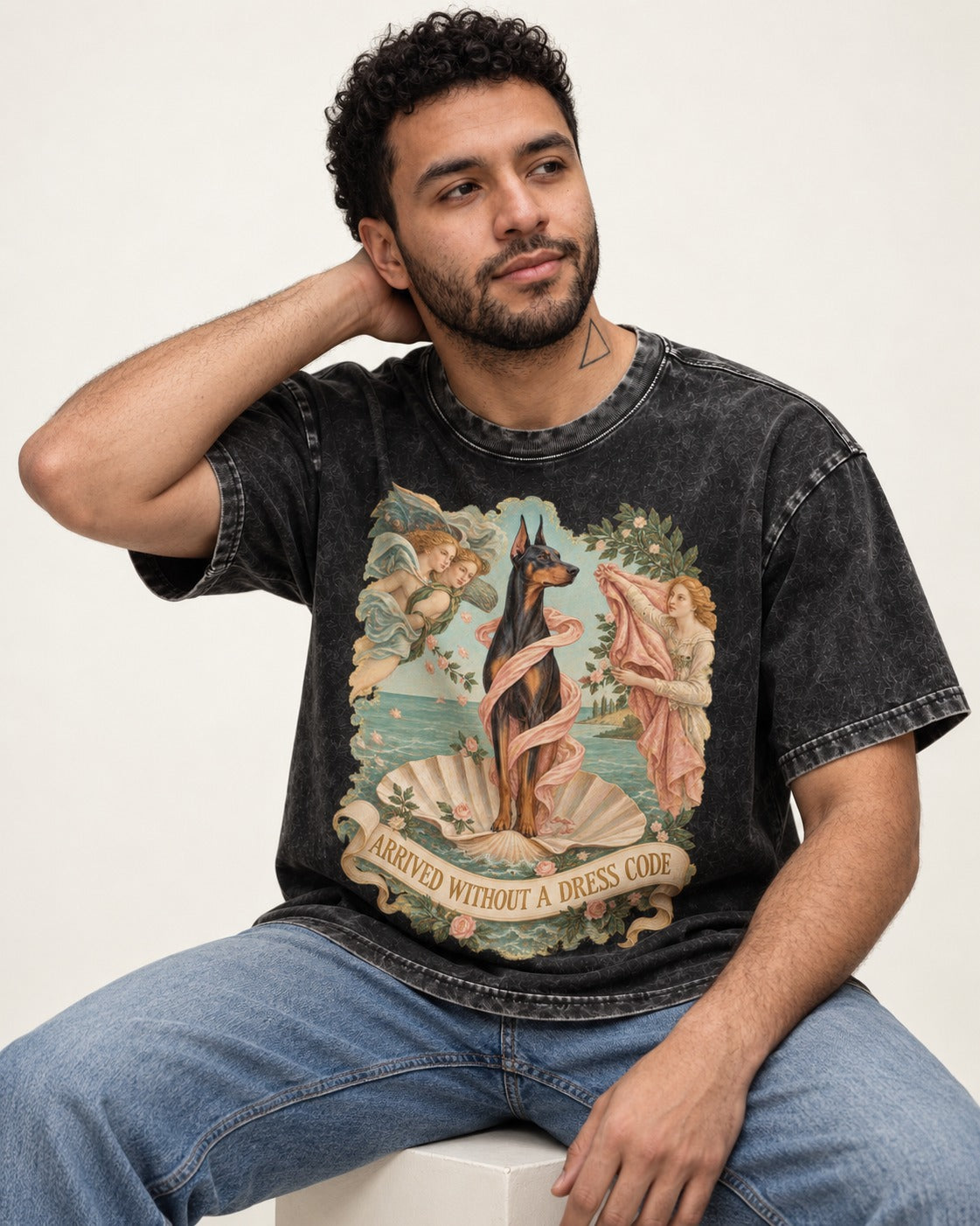 Doberman Arrived Without a Dress Code Renaissance Graphic Washed Tee in Black, worn by a seated model