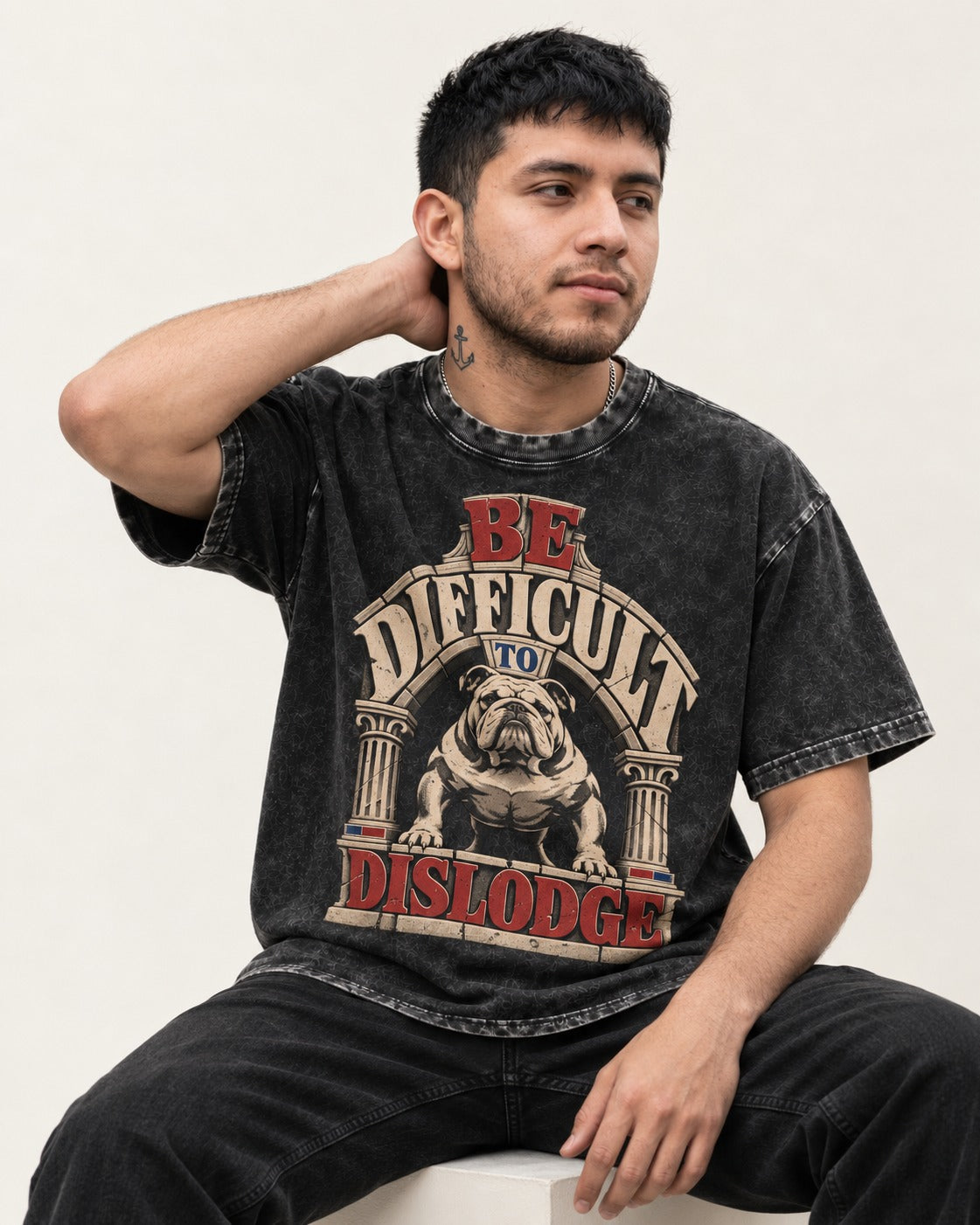 English Bulldog Be Difficult to Dislodge Stone Arch Graphic Washed Tee in Black, worn by a seated model