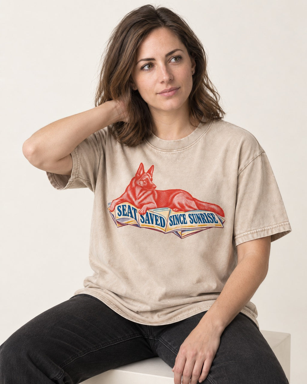 Seat Saved Since Sunrise German Shepherd Dog Washed Tee in Apricot, worn by a seated model