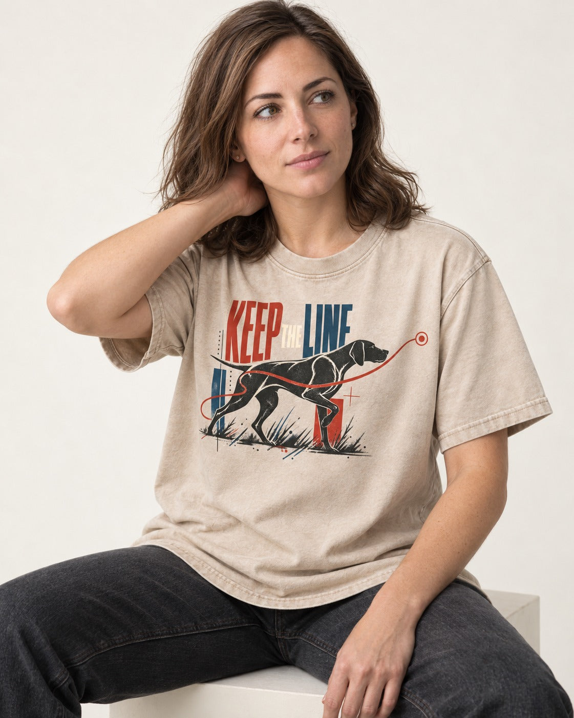 Keep the Line German Shorthaired Pointer Washed Tee in Apricot, worn by a seated model