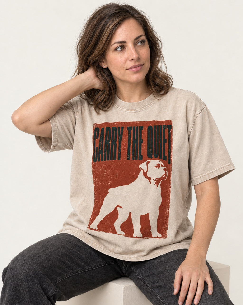 Rottweiler Carry the Quiet Washed Tee in Apricot, worn by a seated model