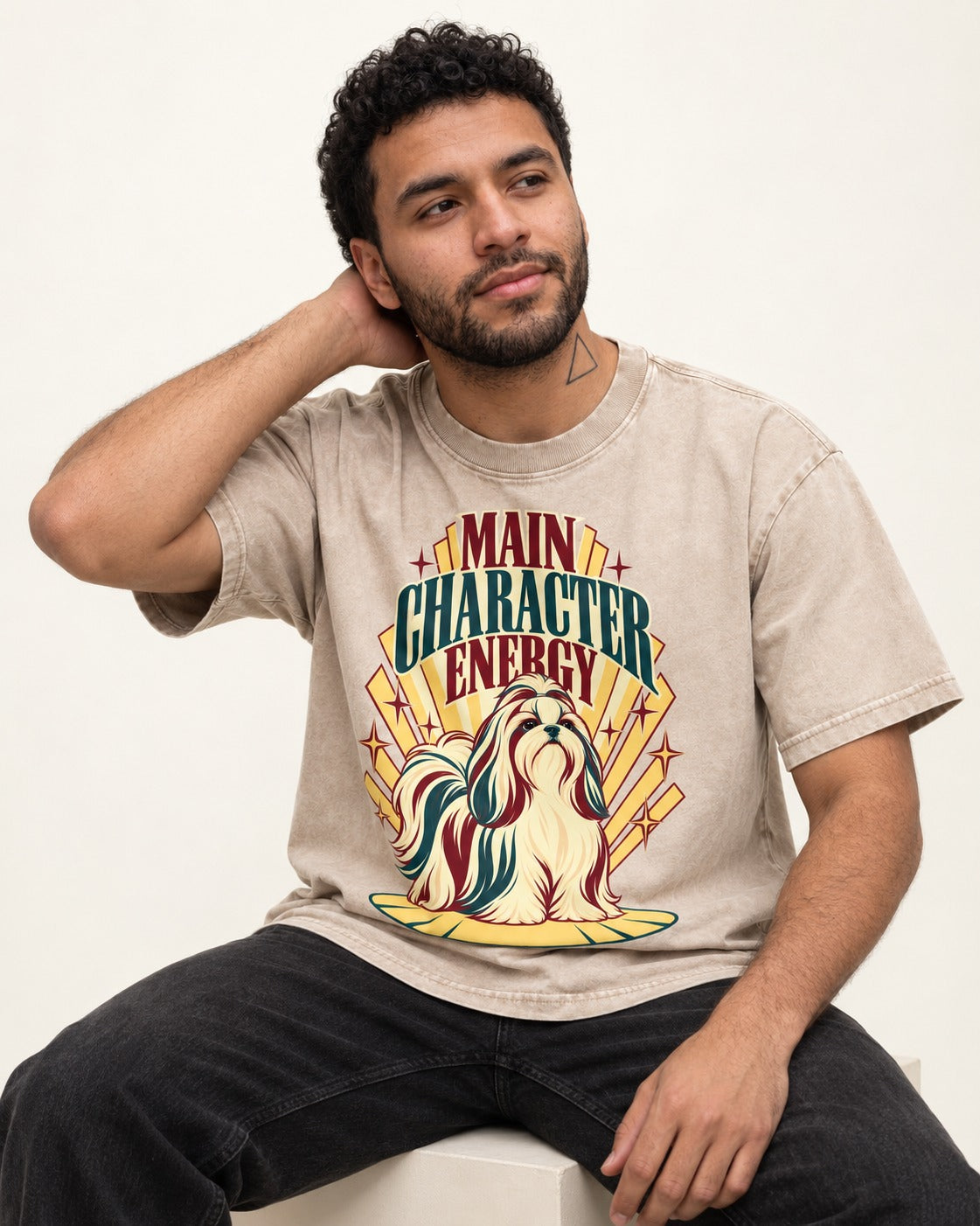Shih Tzu Main Character Energy Art Deco Graphic Washed Tee in Apricot, worn by a seated model