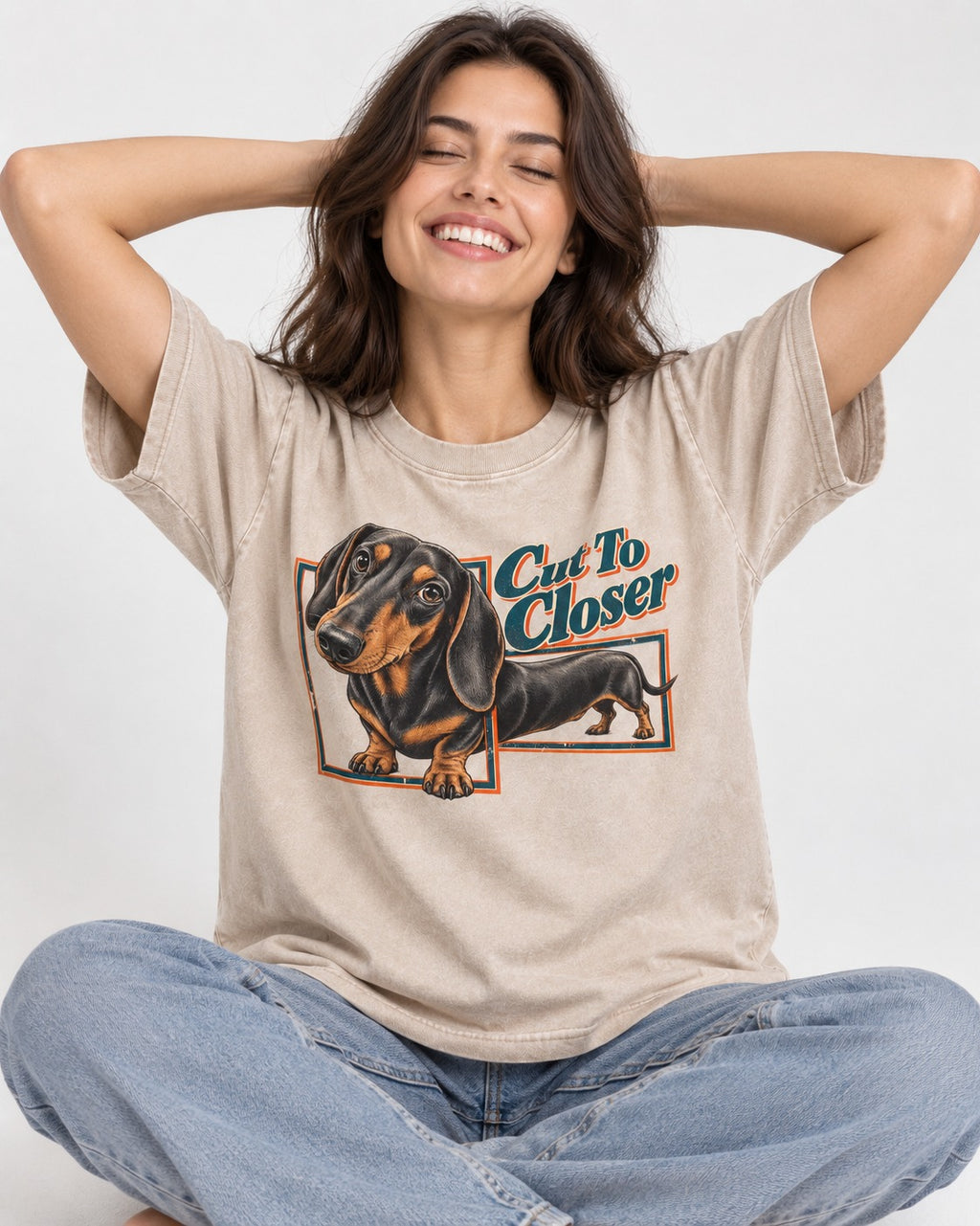 Dachshund Cut to Closer Washed Tee in Apricot, worn by a seated model