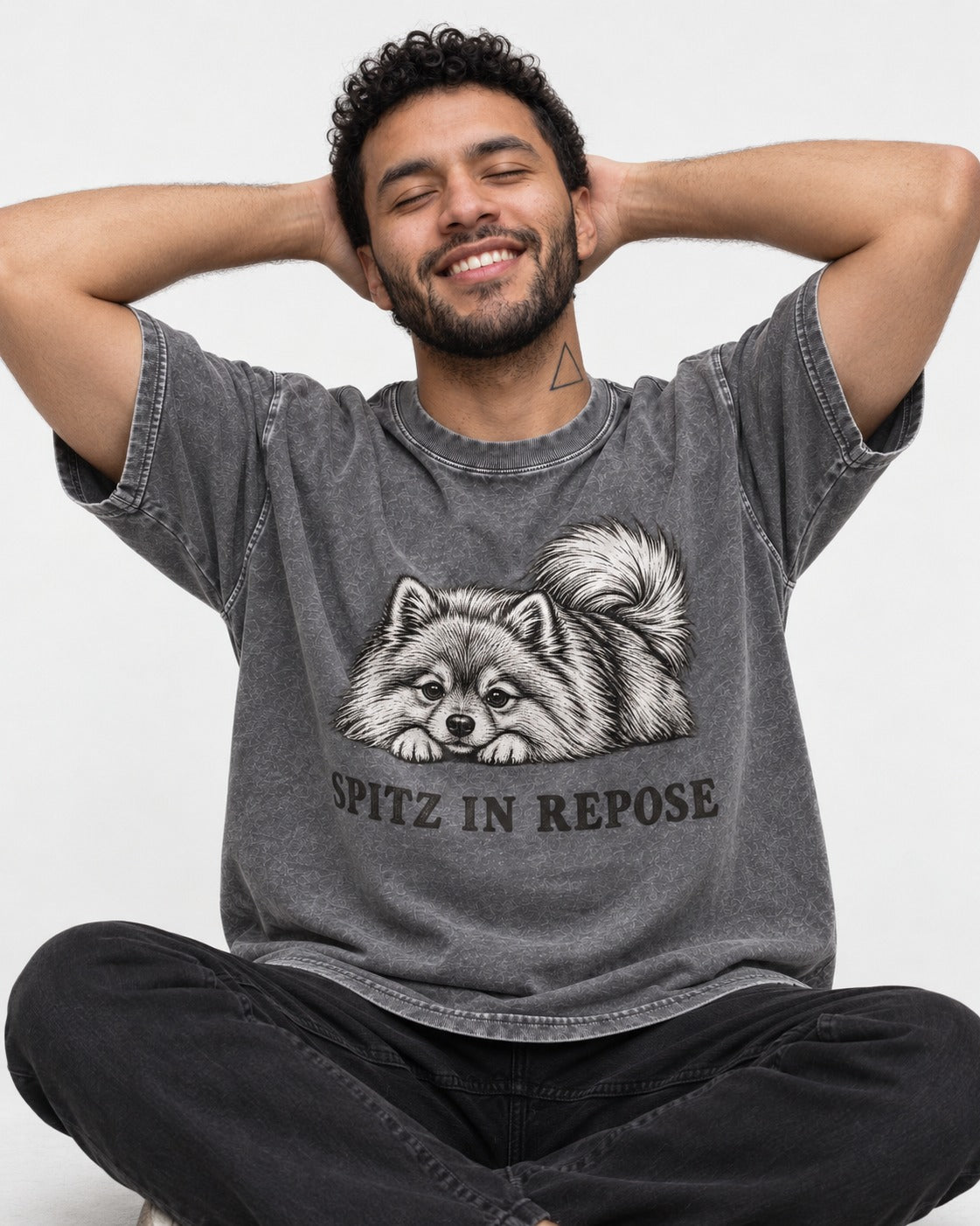 Pomeranian In Repose Washed Tee in Gray, worn by a seated model