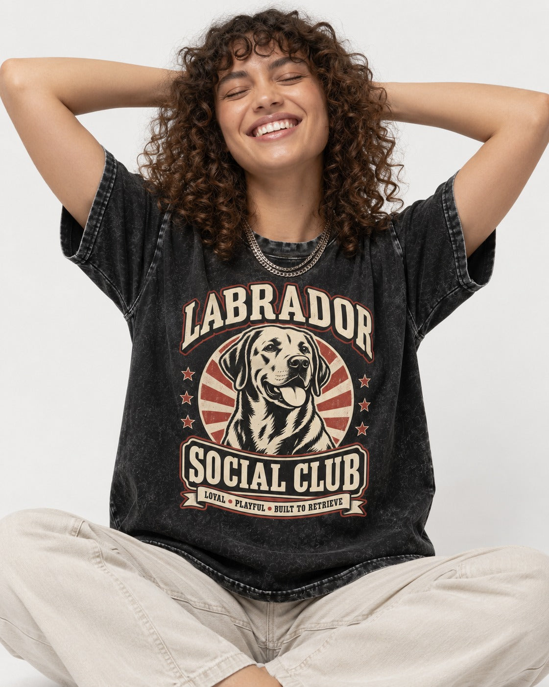 Labrador Retriever Social Club Loyal Playful Built to Retrieve Badge Graphic Washed Tee in Black, worn by a seated model