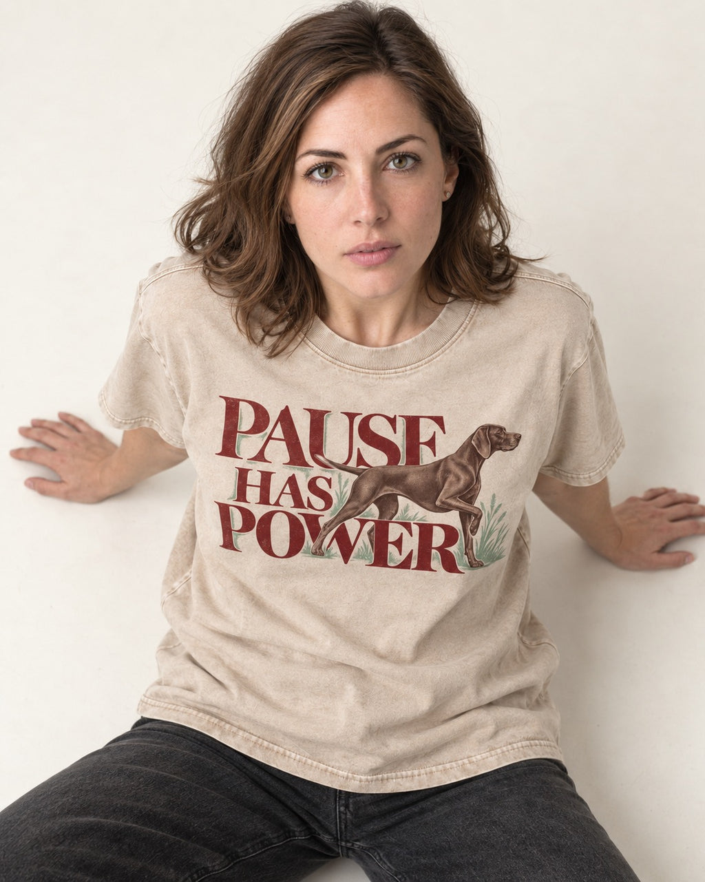 Pause Has Power German Shorthaired Pointer Washed Tee in Apricot, worn by a seated model