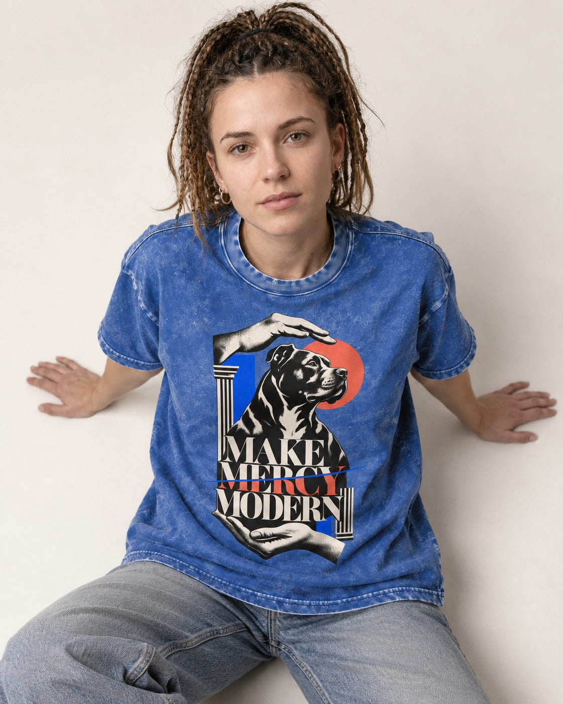 Pitbull Make Mercy Modern Protective Hands Graphic Washed Tee in Royal Blue, worn by a seated model