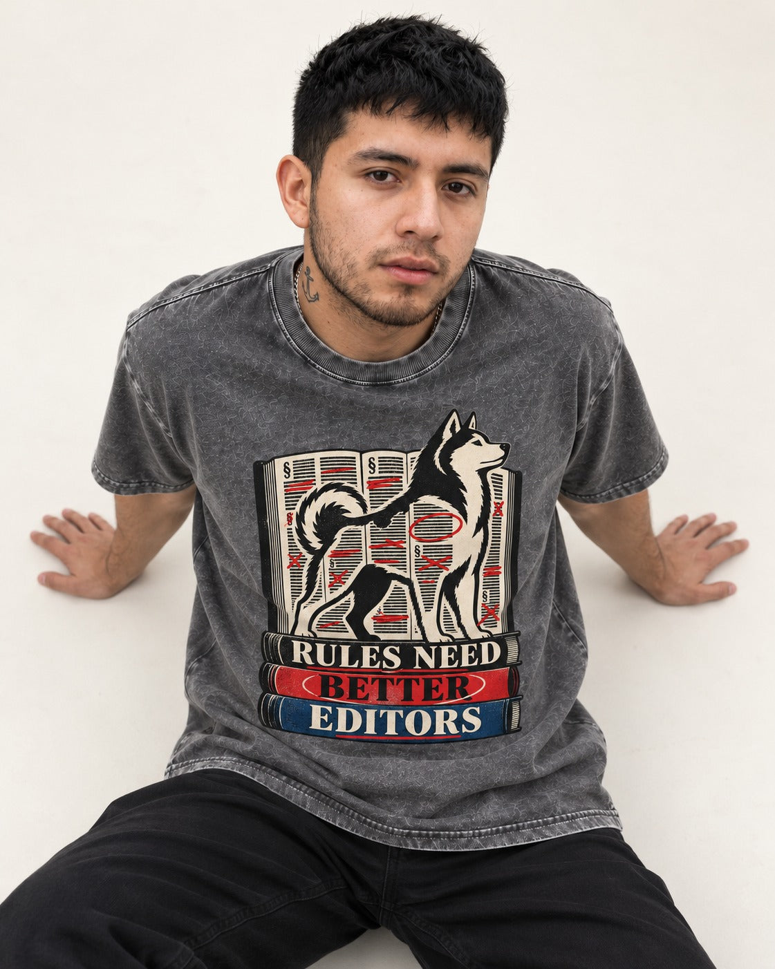 Husky Rules Need Better Editors Book Stack Graphic Washed Tee in Gray, worn by a seated model
