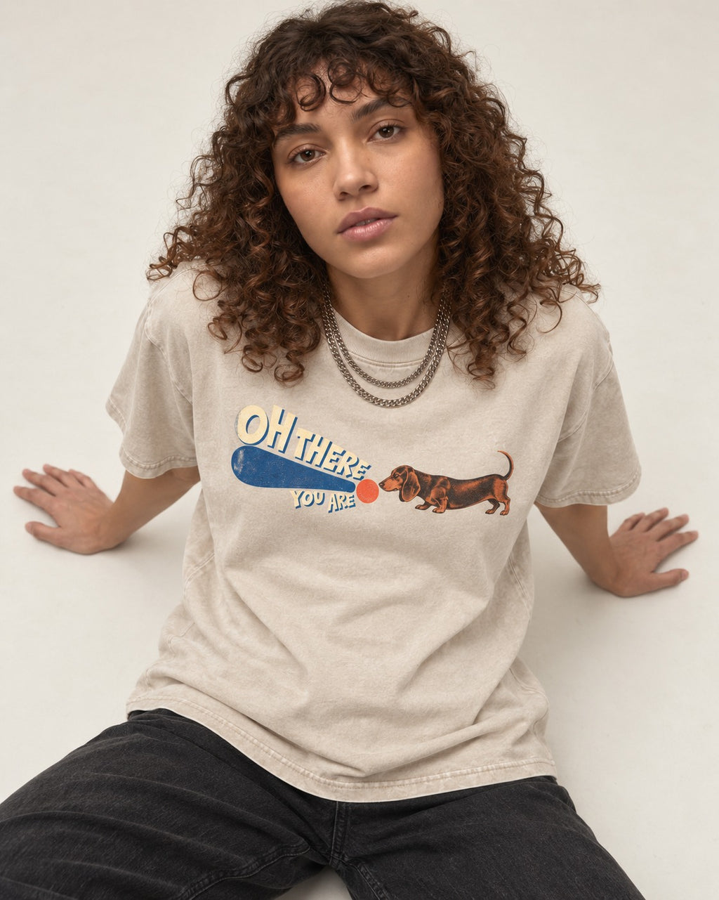 Dachshund Oh There You Are Ball Graphic Washed Tee in Apricot, worn by a seated model