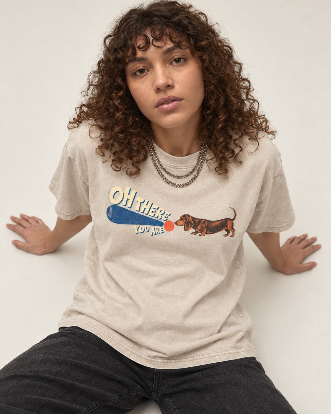 Dachshund Oh There You Are Ball Graphic Washed Tee in Apricot, worn by a seated model
