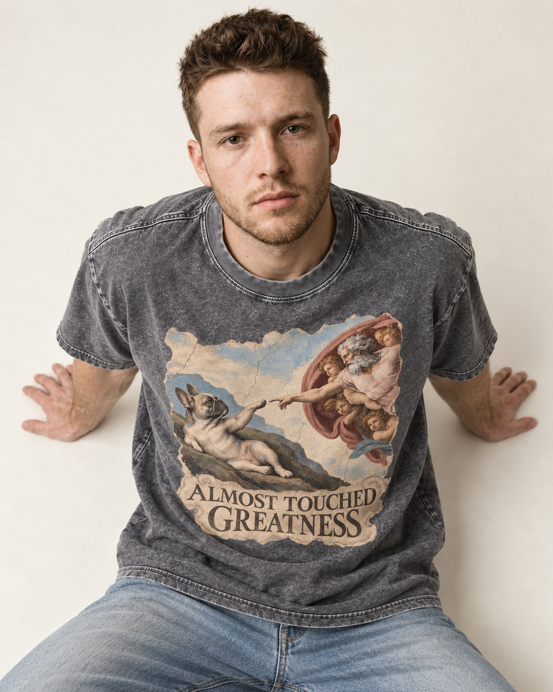 Frenchie Almost Touched Greatness Washed Tee in Gray, worn by a seated model