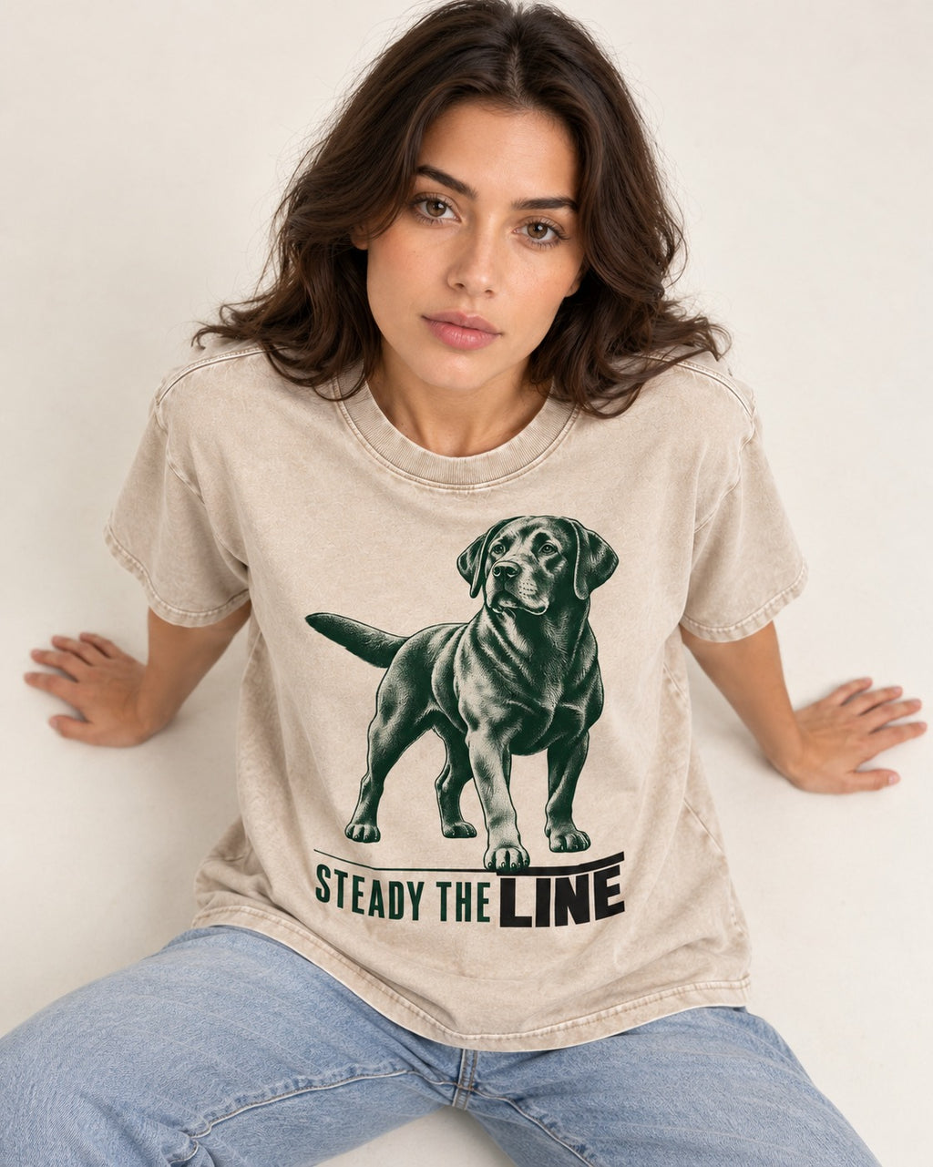 Steady the Line Labrador Retriever Washed Tee in Apricot, worn by a seated model