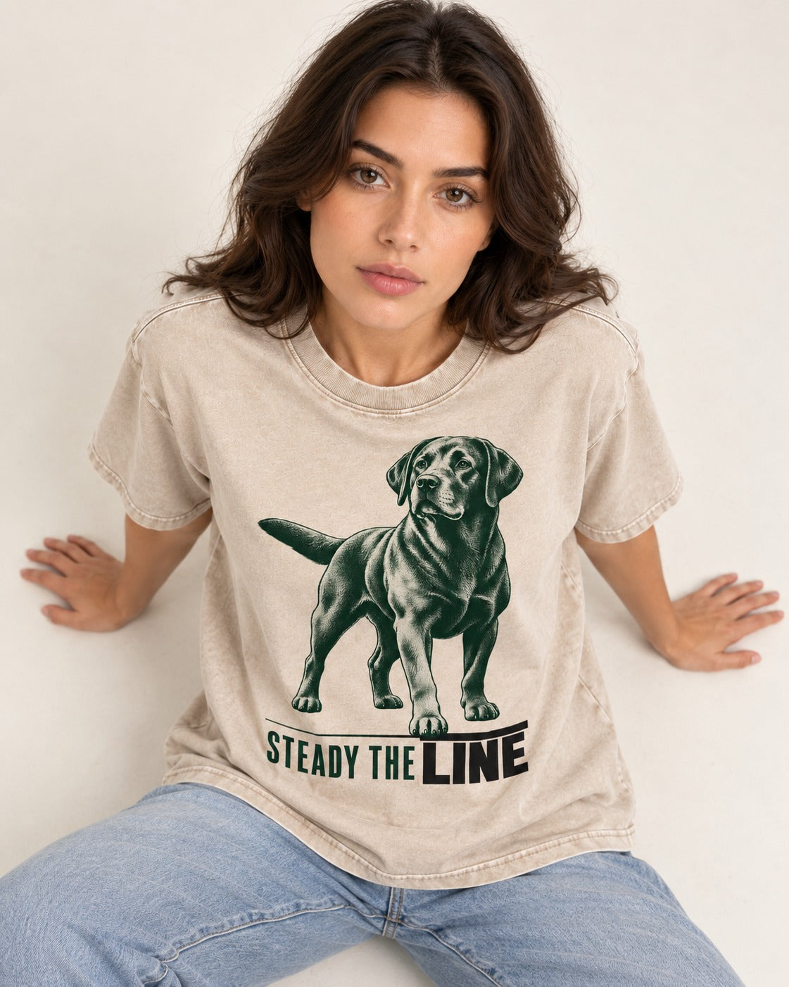 Steady the Line Labrador Retriever Washed Tee in Apricot, worn by a seated model
