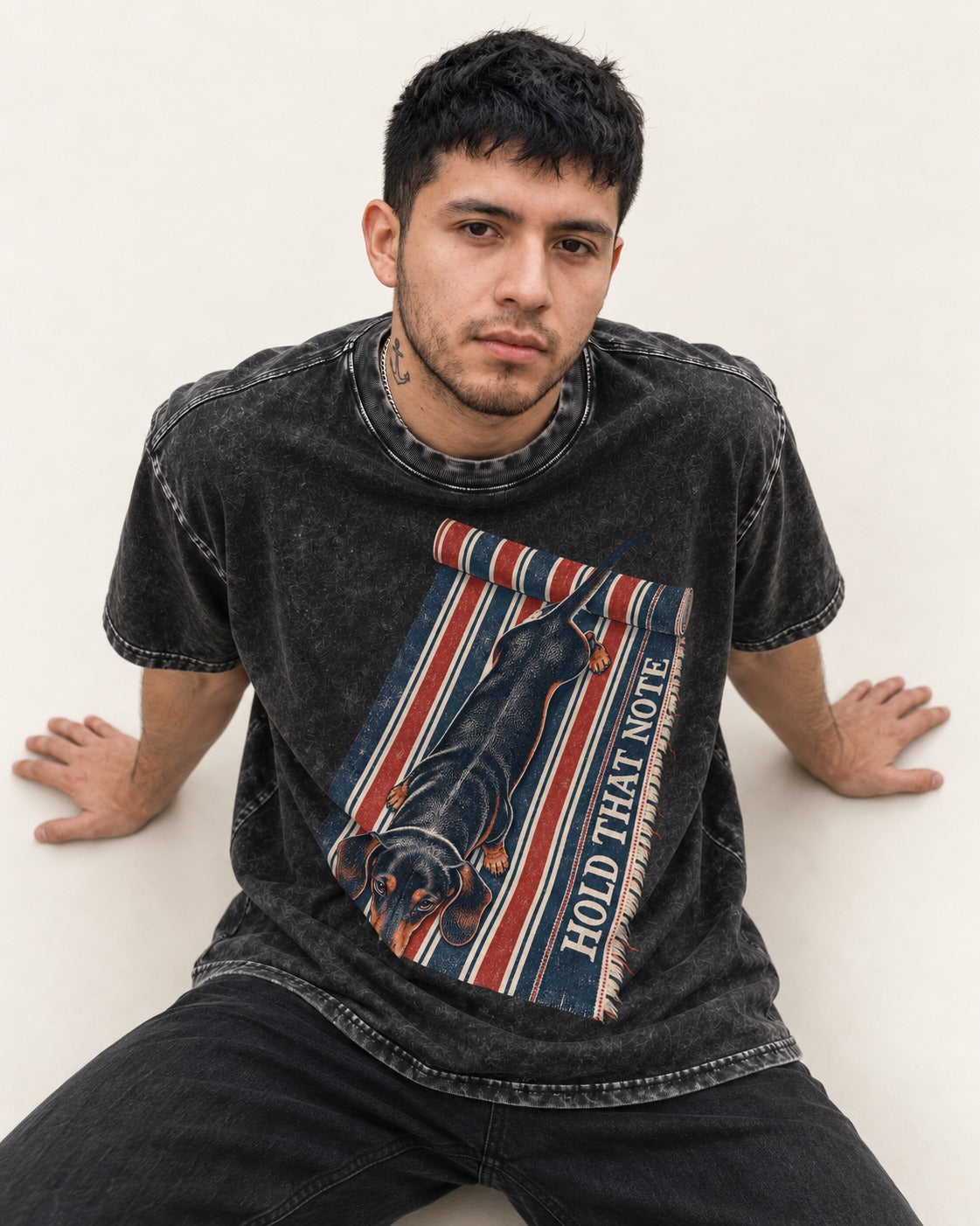 Dachshund Hold That Note Striped Rug Graphic Washed Tee in Black, worn by a seated model