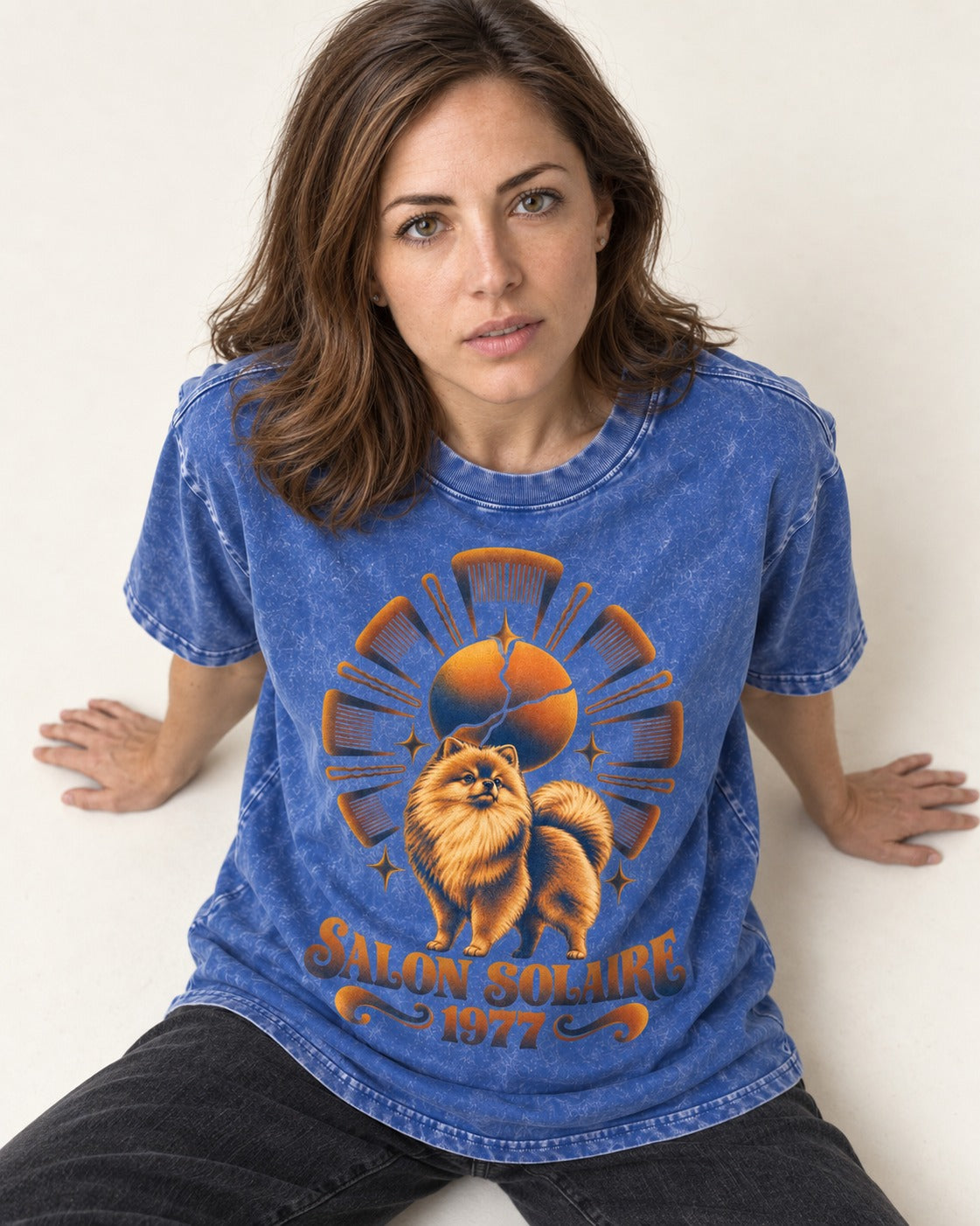 Pomeranian Salon Solaire 1977 Hairbrush Halo Graphic Washed Tee in Royal Blue, worn by a seated model