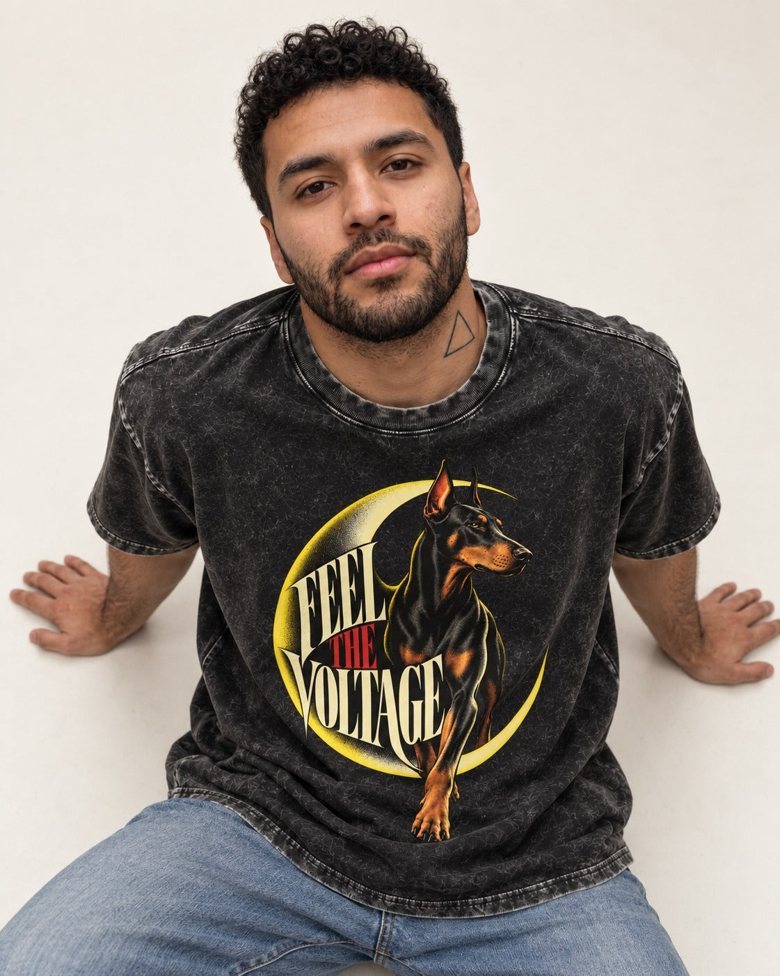 Doberman Feel the Voltage Crescent Portrait Graphic Washed Tee in Black, worn by a seated model