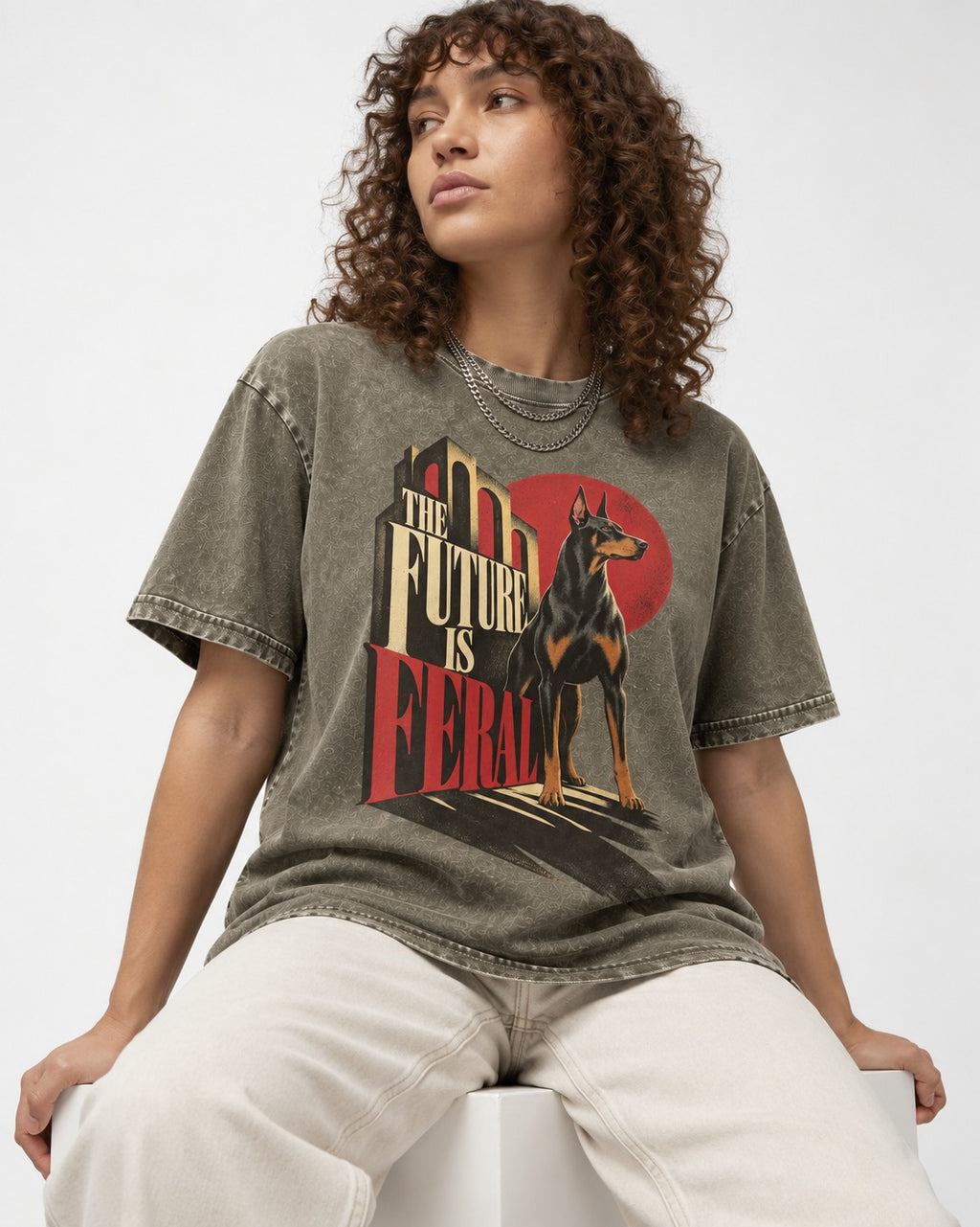 Doberman The Future Is Feral Art Deco Graphic Washed Tee in Army Green, worn by a seated model