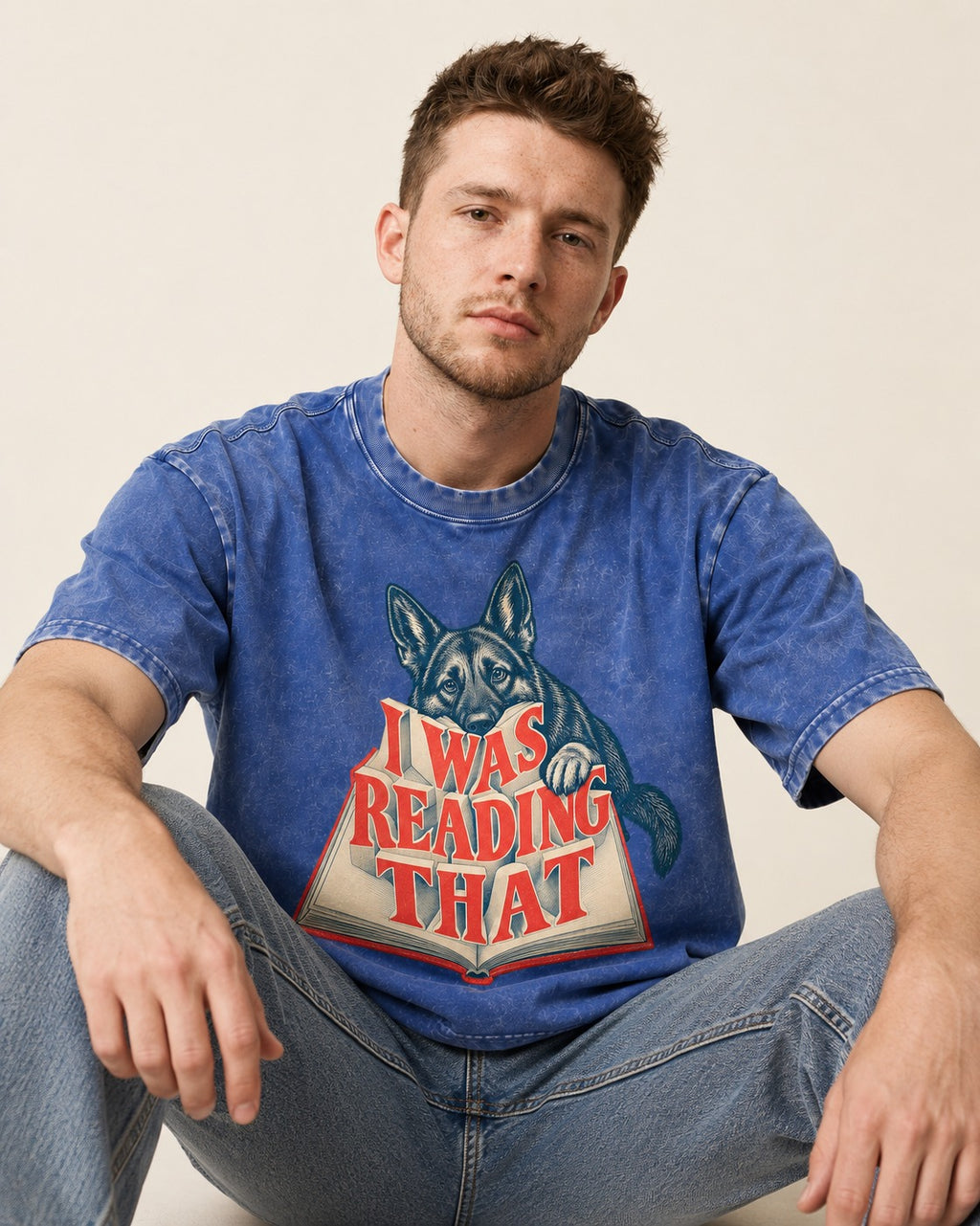 German Shepherd Dog I Was Reading That Open Book Graphic Washed Tee in Royal Blue, worn by a seated model