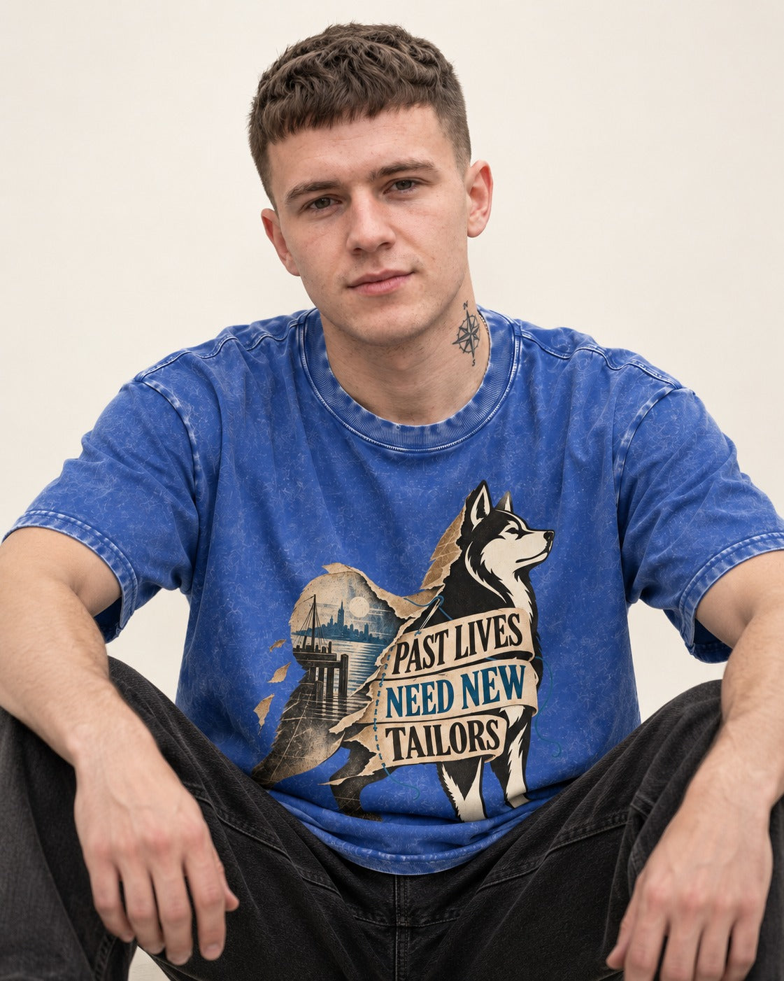 Husky Past Lives Need New Tailors Split Identity Graphic Washed Tee in Royal Blue, worn by a seated model