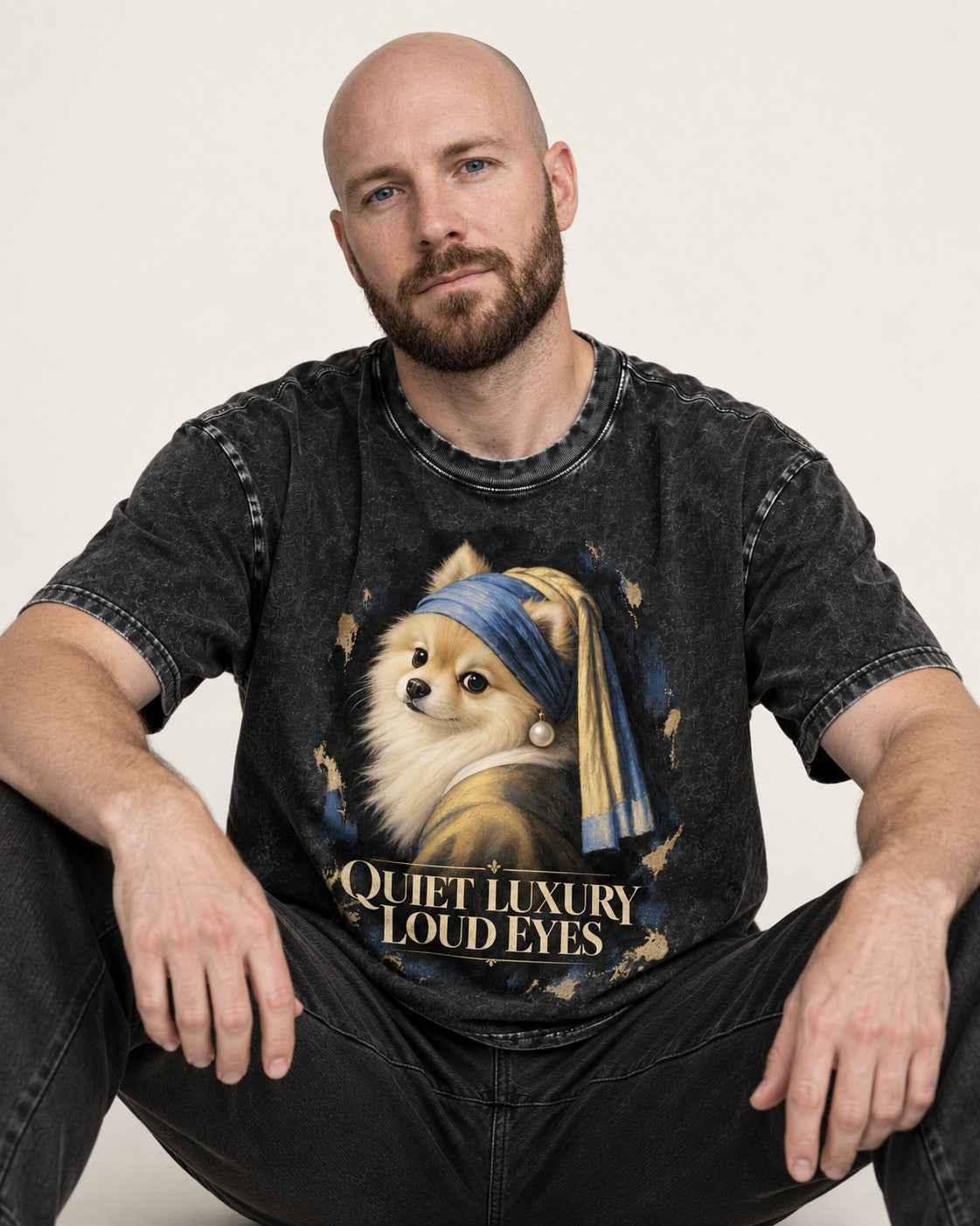 Pomeranian Quiet Luxury Loud Eyes Pearl Portrait Graphic Washed Tee in Black, worn by a seated model