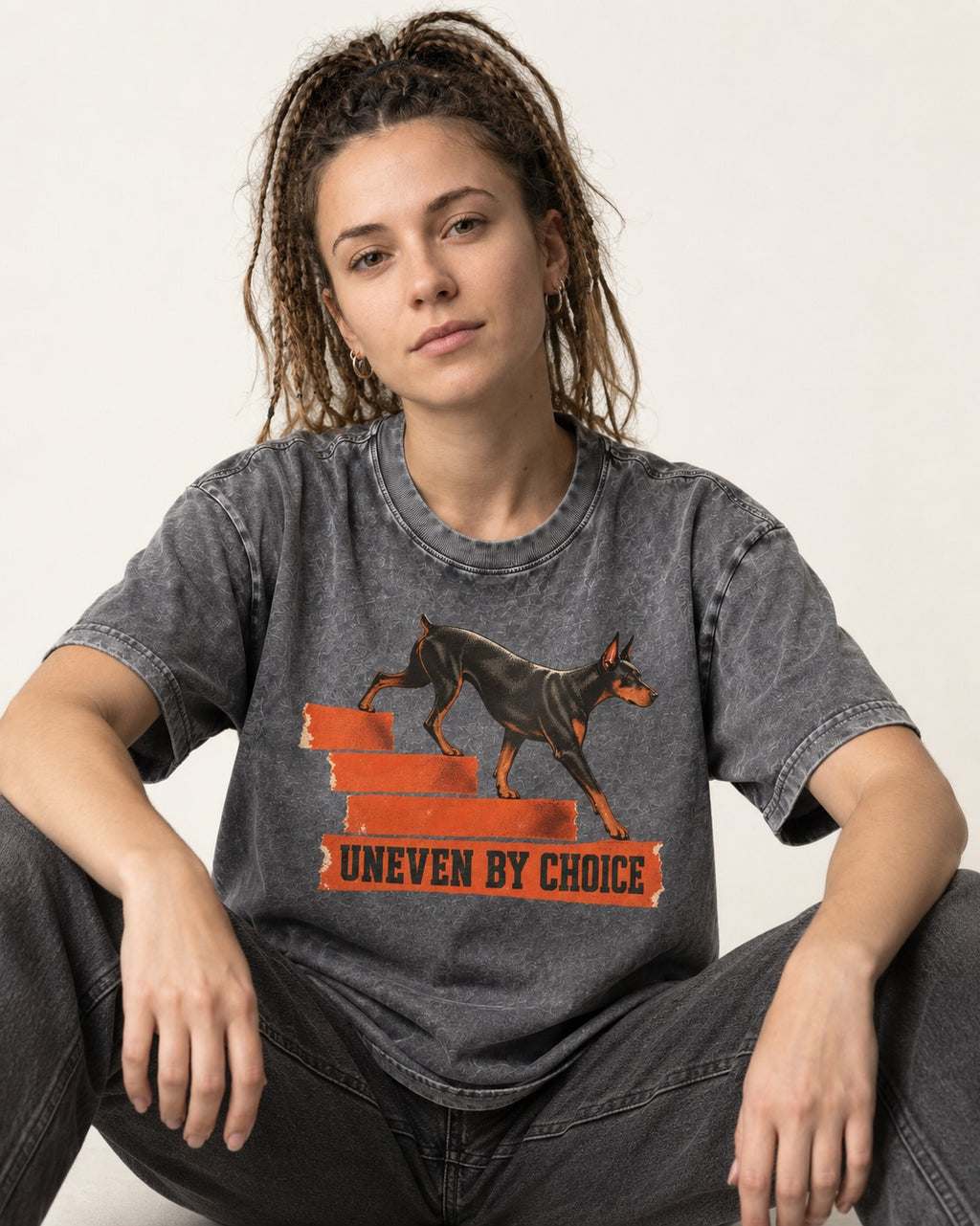 Doberman Uneven by Choice Stair Graphic Washed Tee in Gray, worn by a seated model