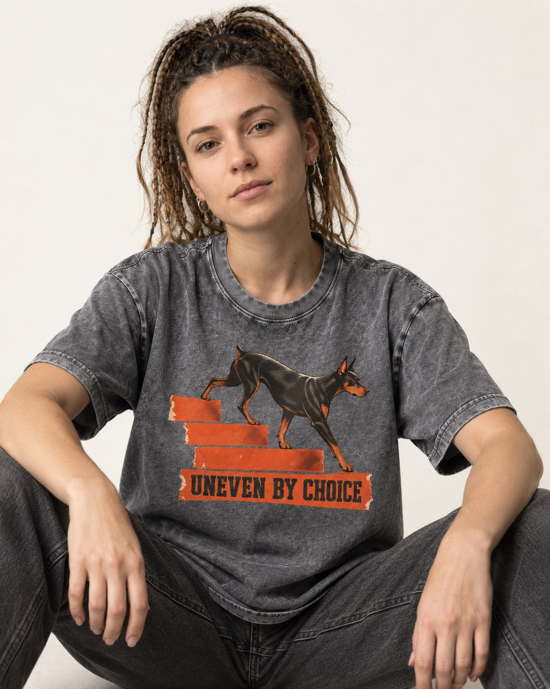 Doberman Uneven by Choice Stair Graphic Washed Tee in Gray, worn by a seated model