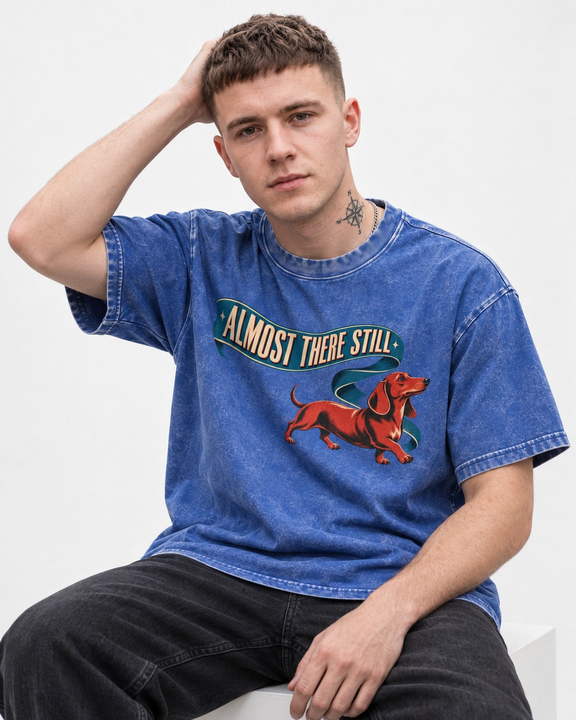 Dachshund Almost There Still Ribbon Graphic Washed Tee in Royal Blue, worn by a seated model