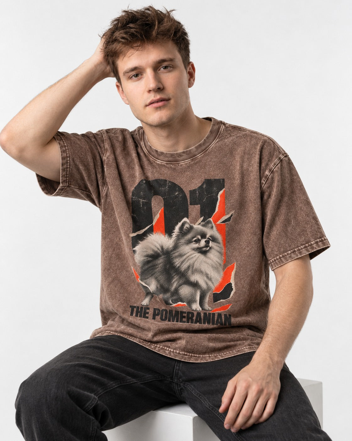 The Pomeranian Washed Tee in Coffee, worn by a seated model