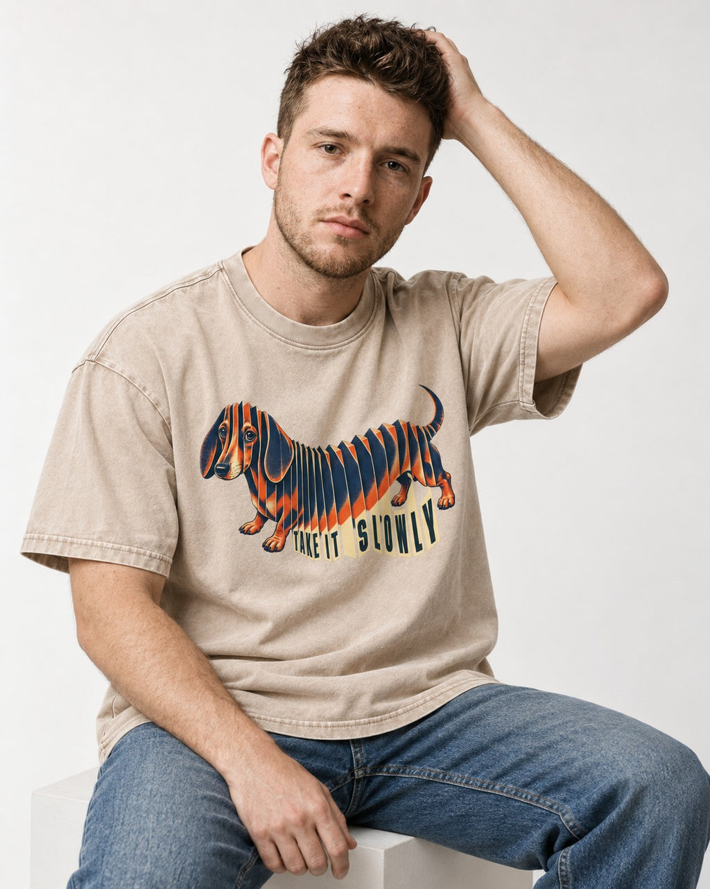 Take It Slowly Dachshund Washed Tee in Apricot, worn by a seated model