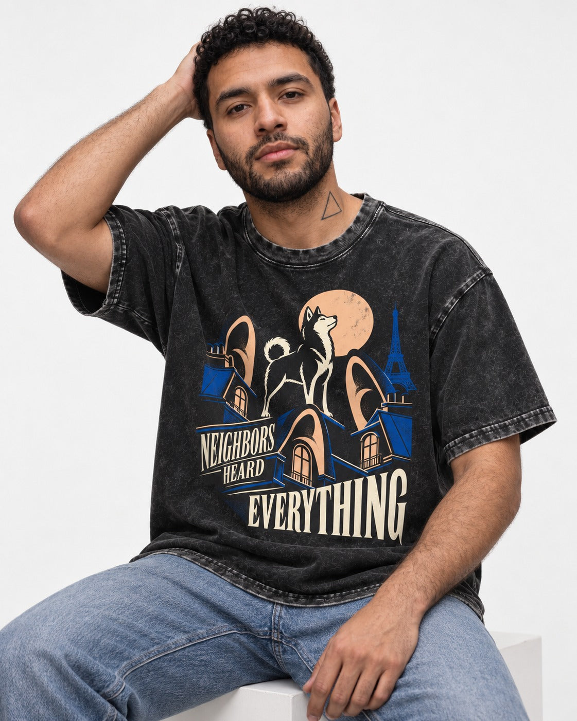 Husky Neighbors Heard Everything Paris Rooftop Graphic Washed Tee in Black, worn by a seated model
