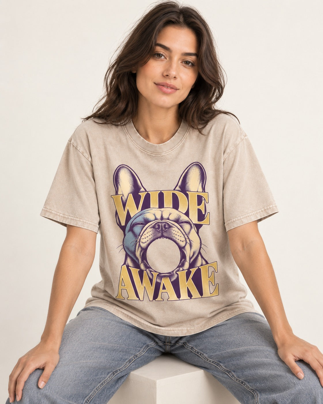 Frenchie Wide Awake Yawn Graphic Washed Tee in Apricot, worn by a seated model