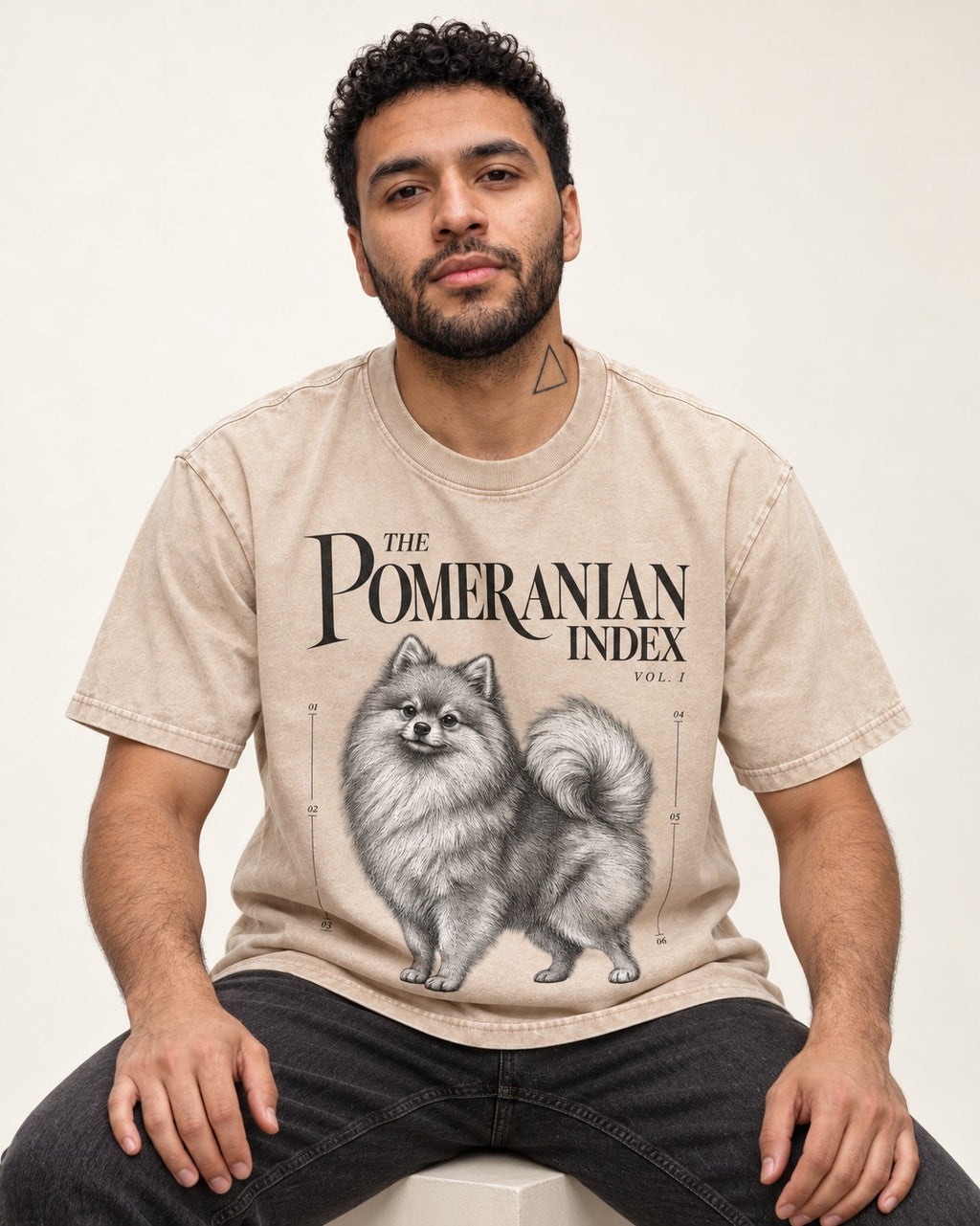 The Pomeranian Index Washed Tee in Apricot, worn by a seated model
