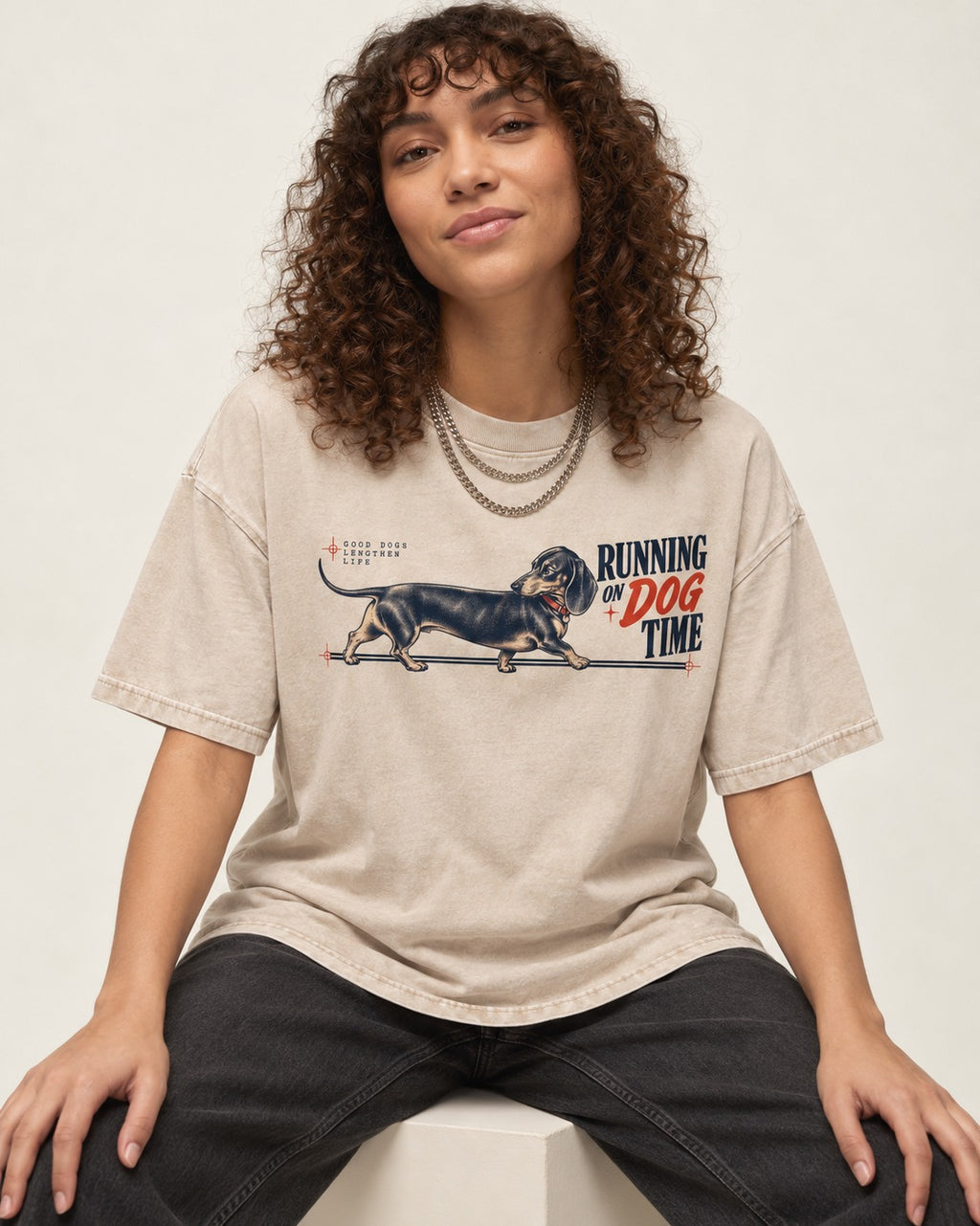 Dachshund Lengthens Life Washed Tee in Apricot, worn by a seated model